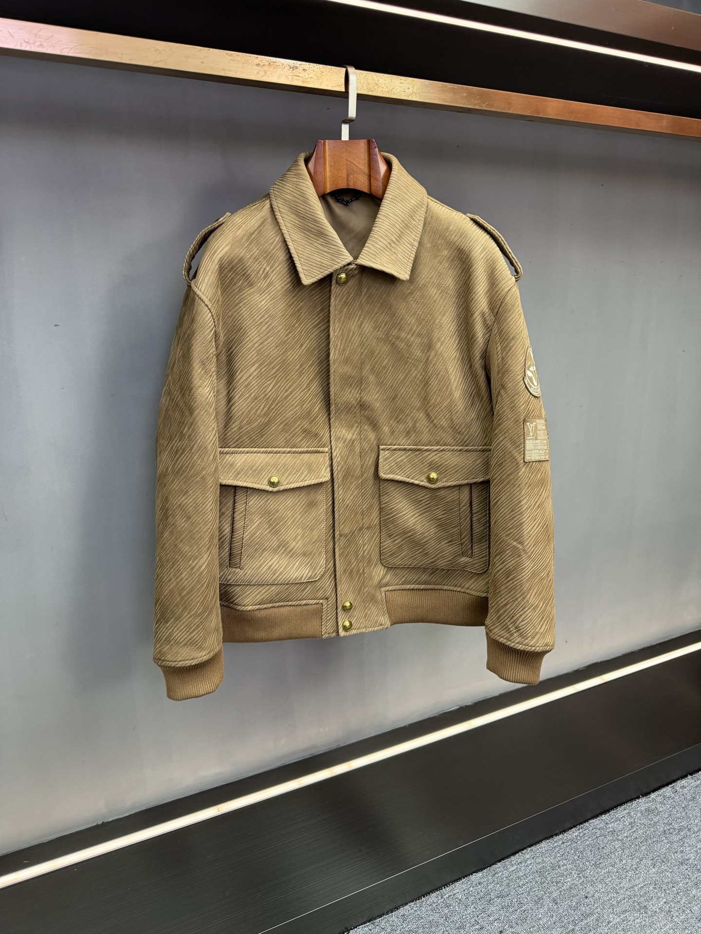 NO:773026,LV Louis Vuitton's new 2026 spring and summer men's sheepskin leather jackets use exquisite craftsmanship and unique design to reinterpret the elegance and style of contemporary men. LV  This jacket is made of khaki suede sheepskin imported from Australia. The leather is delicate and warm, with a rich touch, and has both natural texture and high-end style. What is particularly special is that its surface uses a special burning process, which naturally blends dark and light textures on the leather. Each texture is unique, just like the mark engraved by time, giving the item a strong retro charm and artistic flavor.  The silhouette continues the classic military uniform style, with neat lines outlining stiff shoulders and a three-dimensional silhouette. It not only retains the tough aura of military uniforms, but also incorporates the comfort of modern tailoring. It can show a calm posture regardless of daily commuting or important occasions. The details are even more ingenious. The LV element nameplate inlaid on the left arm echoes the brand logo with a metallic texture, highlighting the brand heritage in a low-key manner, becoming the finishing touch of the overall design.  As a classic color in spring and summer, khaki is versatile and adapts to a variety of dressing scenes, making it easy to control different styles. It is a must-have item for autumn and winter that has both practical value and collection significance. Louis Vuitton uses a century of ingenuity to perfectly integrate materials, craftsmanship and design to present contemporary men with this sheepskin jacket that combines texture, style and recognition, showing its extraordinary taste. Size 48-56,,louis vuitton,louis vuitton,jackets & coats,leather  jacket,sheepskin,Top Customize119860909LV 路易威登2026年春夏新款男士羊皮皮衣,以精湛工艺与独特设计,重新诠释当代男士的优雅与型格.  LV 此款外套甄选澳洲进口卡其色反绒羊皮,皮质细腻温润,触感丰盈,兼具自然质感与高级格调.尤为特别的是,其表面采用特殊烧纹工艺,在皮革之上自然晕染出深浅交织的深色纹路,每一道肌理都独一无二,如同时光镌刻的印记,赋予单品浓郁的复古韵味与艺术气息.  版型上延续经典军装风格,利落线条勾勒出挺括肩线与立体廓形,既保留了军装的硬朗气场,又融入现代剪裁的舒适感,无论日常通勤还是重要场合,皆能展现从容姿态.细节处更见巧思,左臂镶嵌的LV元素铭牌,以金属质感与品牌标识相呼应,低调中彰显品牌底蕴,成为整体设计的点睛之笔.  卡其色作为春夏季节的经典色调,百搭属性适配多种穿搭场景,轻松驾驭不同风格,是兼具实用价值与收藏意义的秋冬必备单品.  路易威登以百年匠心,将材质、工艺与设计完美融合,为当代男士呈现这件集质感、风格与辨识度于一体的羊皮外套,尽显不凡品味. 码数48-56,,louis vuitton,louis vuitton,jackets & coats,leather jacket,sheepskin,Top Customize1,Men's clothing