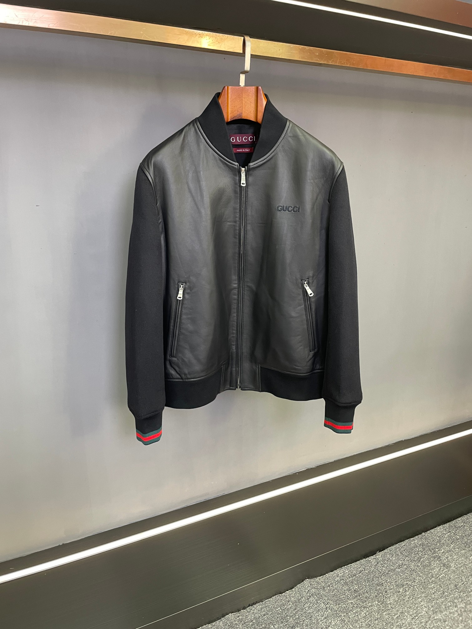 NO:814396,| GUCCI Gucci's new 2026 early spring men's sheepskin leather jacket interprets pioneering style. Entering 2026, Gucci once again reshapes men's fashion silhouettes with outstanding ingenuity. This new sheepskin jacket embodies the brand's classic elements and innovative ideas, making it a wardrobe treasure that gentlemen cannot miss. Gucci  The main body of the jacket is made of black sheepskin imported from Australia. Its delicate texture and soft touch complement each other, exuding an innate sense of luxury. The black tone is calm and restrained, suitable for various wearing scenarios, from business negotiations to casual gatherings, and can highlight the wearer's extraordinary taste.  The sleeves and back panel are spliced with black cashmere fabric, which not only creates a unique sense of layering between materials, but also improves the overall thermal insulation performance, allowing you to stay warm and stylish in the cooler autumn and winter. The softness of cashmere and the stiffness of sheepskin complement each other, giving more comfort and casualness to the wearing experience.  At the cuffs, the classic contrasting blue and red threads are eye-catching. This GUCCI iconic design element releases brand recognition in a low-key manner and injects a touch of vitality into the overall look. It is a tribute to the brand's century-old fashion heritage and an expression of the current trend attitude. Whether paired with a simple white shirt and trousers to create a smart business style; or worn with a personalized T-shirt and jeans for a casual street style, this jacket can be easily worn and becomes the finishing touch of the look.  Gucci's new 2026 early spring men's sheepskin jacket perfectly integrates top materials, ingenious design and practical functions. It resonates with fashion and quality. We sincerely invite you to go to offline stores to taste and purchase, and start your own autumn and winter fashion journey. Size M-4XL,,gucci,gucci,jeans,jackets & coats,shirts,tees,t-shirt,leather jacket,sheepskin,Top Customize119860909| GUCCI 古驰2026年早春新款男士羊皮夹克皮衣,诠释先锋型格  踏入2026,古驰再度以卓越匠心,重塑男士时尚轮廓.这款全新羊皮夹克,凝聚品牌经典元素与创新巧思,是绅士们不容错过的衣橱臻品.  古驰 夹克的主体采用澳洲进口黑色羊皮,细腻的纹理与柔软的触感相得益彰,散发着与生俱来的奢华质感.黑色基调沉稳内敛,适配各类穿搭场景,从商务洽谈至休闲聚会,皆能彰显穿着者的不凡品味.  袖子与后幅选用黑色羊绒面料拼接,不仅在材质碰撞间打造出独特的层次感,更提升了整体的保暖性能,让您在渐凉的秋冬也能温暖有型.羊绒的软糯与羊皮的挺括相辅相成,为穿着体验赋予更多舒适与随性.  袖口处,经典的蓝红撞色螺纹醒目而吸睛,这一GUCCI标志性设计元素,在低调中释放品牌辨识度,为整体造型注入一抹灵动活力,是对品牌百年时尚传承的致敬,也是当下潮流态度的表达.  无论是搭配简约白衬衫与西裤,打造干练商务风；还是内搭个性T恤和牛仔裤,演绎休闲街头范,这件夹克都能轻松驾驭,成为造型的点睛之笔.  古驰2026早春新款男士羊皮夹克,将顶级材质、匠心设计与实用功能完美融合,是时尚与品质的共鸣,诚邀您前往线下门店品鉴选购,开启属于您的秋冬时尚之旅 . 码数M-4XL,,gucci,gucci,jeans,jackets & coats,shirts,tees，t-shirt,leather jacket,sheepskin,Top Customize1,Men's clothing
