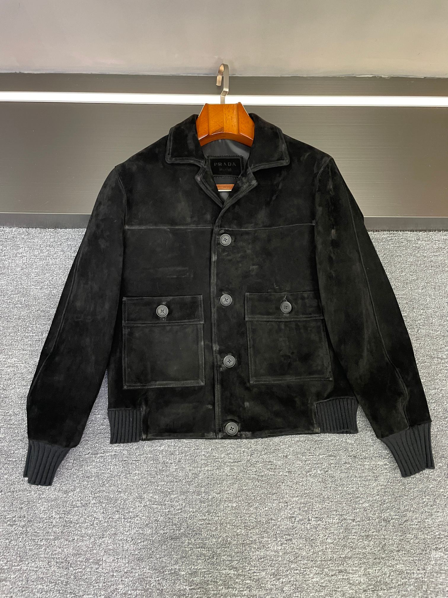NO:814090,This Prada suede sheepskin jacket is the 'gentle armor' of autumn and winter style~ In Prada's 2026 spring and summer men's new style, this suede sheepskin jacket hides an ingenuity that makes people's hearts flutter at first sight - it combines the neatness of work clothes with the warmth of sheepskin, showing texture without lacking the daily relaxation.  The selected suede sheepskin imported from New Zealand has a delicate velvet feel that you can remember, as if it has been gently polished by time. The brown color has a retro filter, and the upper body is low-key and yuppie; the black color exudes a calm aura, not picky in style but with a sense of luxury. Both colors avoid exaggeration, but can easily wear a unique style.  The small lapel design of the work clothes is very skillful. It does not deliberately emphasize toughness, but adds a casual and comfortable everyday feel. Whether it is worn open or buttoned up, it can highlight the neat silhouette and is also very tolerant to various body shapes.  The iconic triangle logo on the lower back of the collar is a tacit understanding of Prada hidden in the details - it is not straightforward and eye-catching, but when you raise your hand and turn around, it quietly reveals its own recognizable texture, like a tacit little signal between people who understand.  Boys wear it with jeans for a casual street feel, with khaki overalls for a retro workwear style, and even with dark trousers it can hold up to light business occasions. This kind of design that hides 'high-end' in daily life and balances 'practical' and 'fashionable' just right is probably what fascinates Prada ~ Friends who like low-key textures, you may want to pay more attention ~ Size 48-56.,, prada, prada, jeans, jackets &  coats,sheepskin,Top Customize119860909这件普拉达反绒羊皮外套,是秋冬型格的「温柔铠甲」～ 普拉达 Prada 2026春夏男士新款里,这件反绒羊皮外套藏着让人一眼心动的巧思——它把工装的利落和羊皮的温润揉得刚好,既显质感,又不缺日常的松弛感. 精选的新西兰进口反绒羊皮,摸上去是能记住的细腻绒感,像被时光轻轻打磨过的温润.棕色自带复古滤镜,上身是低调的雅痞气；黑色则透着沉稳气场,不挑风格却自带高级感,两个颜色都避开了浮夸,却能轻松穿出独有的格调. 工装小翻领设计很见功力,没有刻意强调硬朗,反而多了份随性自在的日常感,无论是敞开穿还是扣起领口,都能衬出利落轮廓,对各种身形的包容度也很友好.后衣领下方的标志性三角标贴皮,是Prada藏在细节里的默契——不直白抢眼,却在抬手转身时悄悄露出自带辨识度的质感,像懂的人之间心照不宣的小信号. 男生穿它,搭牛仔裤是随性的街头感,配卡其色工装裤又能穿出复古工装风,甚至搭深色西裤也能hold住轻商务场合.这种把「高级」藏在日常里,把「实用」和「时髦」平衡得恰到好处的设计,大概就是Prada让人着迷的地方吧～ 喜欢低调质感的朋友,不妨多留意一眼呀～ 码数48-56.,,prada,prada,jeans,jackets & coats,sheepskin,Top Customize1,Men's clothing