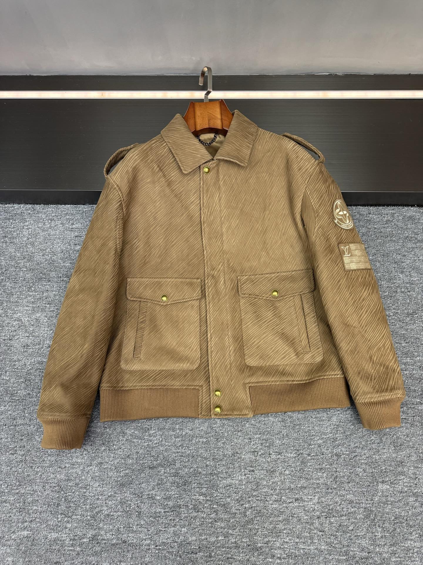 NO:773029,This is what a jersey should look like!  Louis Vuitton's new sheepskin jacket is so awesome. Lujia's 2026 spring and summer new men's sheepskin jacket has an aura of 'keep away from strangers' just by hanging it there. Putting it on will directly make your style look better~  The selected khaki suede sheepskin imported from Australia feels grainy and delicate, gentle and powerful. The most amazing thing is the special burnt pattern process on the surface. The dark texture is like a naturally growing texture. Each piece has a unique retro feel, as if the story of the years is worn on the body.  The military-style style really understands boys' aesthetics - the neat tailoring makes the shoulders and back lines super straight, not tight or draggy, and you can feel comfortable even when you raise your hands and turn around. The LV element badge inlaid on the left arm is the finishing touch. The metallic luster and matte leather collide to create a low-key edge. There is no need to show off deliberately, and the taste is all hidden in the details.  Khaki itself is so versatile that it can be worn with overalls for a cool street style. Paired with a sweater and trousers, you can wear it with a yuppie look. One piece can take care of the entire spring and summer look. This kind of practical and beautiful item is really hard to refuse~ Size 48-56,,louis vuitton,louis vuitton,louis vuitton,louis vuitton,jackets & coats,sheepskin,Top Customize119860909这才是战袍该有的样子！路易威登新款羊皮外套太鲨了  驴家 2026春夏新款这件男士羊皮外套,光是挂在那里就自带「生人勿近」的气场,穿上更是直接把型格拉满～  精选澳洲进口的卡其色反绒羊皮,摸上去是那种带着颗粒感的细腻,温柔又有力量.最绝的是表面的特殊烧纹工艺,深色纹路像自然生长的肌理,每一件都带着独一无二的复古感,仿佛把岁月的故事穿在了身上.  军装风版型真的太懂男生审美了——利落的剪裁衬得肩背线条超挺拔,不紧绷也不拖沓,抬手转身都透着自在.左臂镶嵌的LV元素徽章是点睛之笔,金属光泽和哑光皮革碰撞出低调的锋芒,不用刻意炫耀,细节里全是藏不住的品味.  卡其色本身就百搭到犯规,配工装裤是街头酷盖,搭针织衫配西裤又能穿出雅痞感,一件能承包整个春夏的造型,这种实用性与颜值并存的单品,真的很难让人拒绝～  码数48-56,,louis vuitton,louis vuitton,louis vuitton,louis vuitton,jackets & coats,sheepskin,Top Customize1,Men's clothing