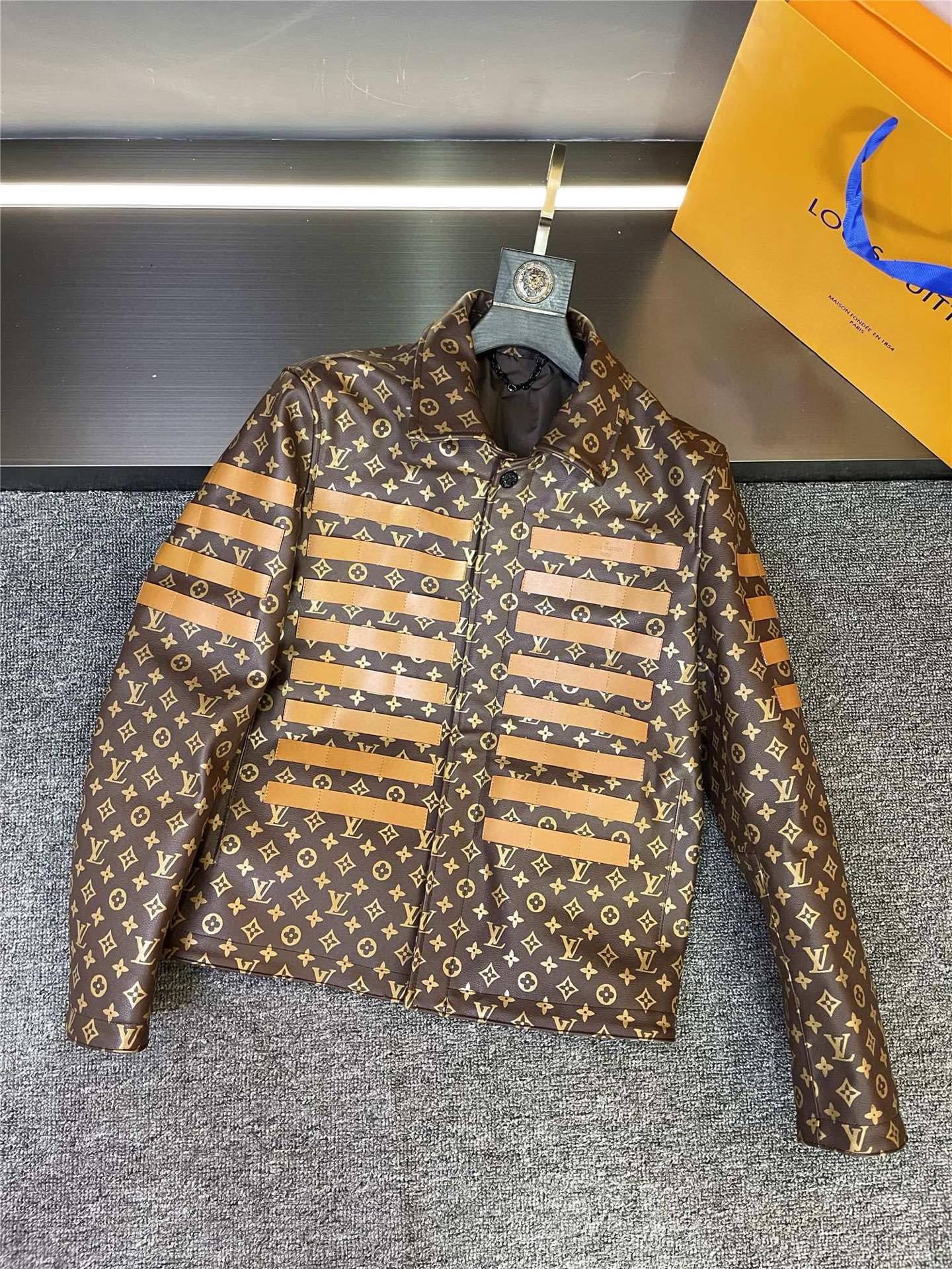 NO:773047,Louis Vuitton LV 2026 spring and summer new cowhide leather jacket, flat lay detail LV's leather jacket is made of first-layer brown calfskin imported from Spain, with extraordinary texture. When you touch it, the delicate texture and soft touch instantly make people feel the charm of top quality. Every inch of leather seems to tell Louis Vuitton's exquisite craftsmanship and luxury heritage.  The design of the same style for men and women makes it the darling of the fashion industry. Whether you are a handsome man or an elegant woman, you can easily wear this leather jacket, showing your unique personality and charm. Classic LV  Five-flower print is a symbol of fashion and quality. It adds elegance and luxury to this leather jacket, making people instantly recognize it as a Louis Vuitton masterpiece. The yellow cowhide stripes on the chest and sleeves inject vitality and fashion into the overall look, making this leather jacket even more outstanding. The yellow cowhide strips are used to depict the giant Louis Vuitton on the back.  The LOGO is even more domineering. This iconic pattern not only highlights the charm of the brand, but also an expression of fashion attitude. No matter where you go, you can become the center of attention. LV has always been a leader in fashion and quality, and this 26-year-old new cowhide leather jacket brings these two characteristics to the extreme. It is not only a piece of clothing, but also a work of art and a fashion treasure worth collecting. Size M-3XL, Louis Vuitton, Louis  vuitton,leather jacket,cowhide,Top Customize119860909路易威登 LV 2026 春夏新款牛皮皮衣,平铺细节图  LV这款皮衣采用西班牙进口头层棕色小牛皮,质感非凡.触摸上去,那细腻的纹理和柔软的触感,瞬间让人感受到顶级品质的魅力.每一寸皮革都仿佛在诉说着路易威登的精湛工艺与奢华传承.  男女同款的设计,更是让它成为时尚界的宠儿.无论是帅气的男士还是优雅的女士,都能轻松驾驭这款皮衣,展现出独特的个性与魅力.  经典的 LV 五花印花,是时尚的标志,也是品质的象征.它为这件皮衣增添了一份优雅与奢华,让人一眼就能认出这是路易威登的杰作.而胸前以及袖子上的黄色牛皮条纹装饰,则为整体造型注入了活力与时尚感,让这件皮衣更加出众.  后背使用黄色牛皮条刻画出的巨型 路易威登 LOGO,更是霸气十足.这个标志性的图案,不仅彰显了品牌的魅力,更是一种时尚态度的表达.无论你走在哪里,都能成为众人瞩目的焦点.  LV一直以来都是时尚与品质的引领者,这款 26年新款牛皮皮衣更是将这两个特点发挥到了极致.它不仅仅是一件衣服,更是一件艺术品,一件值得珍藏的时尚宝藏.  码数M-3XL,,louis vuitton,louis vuitton,leather jacket,cowhide,Top Customize1,Men's clothing