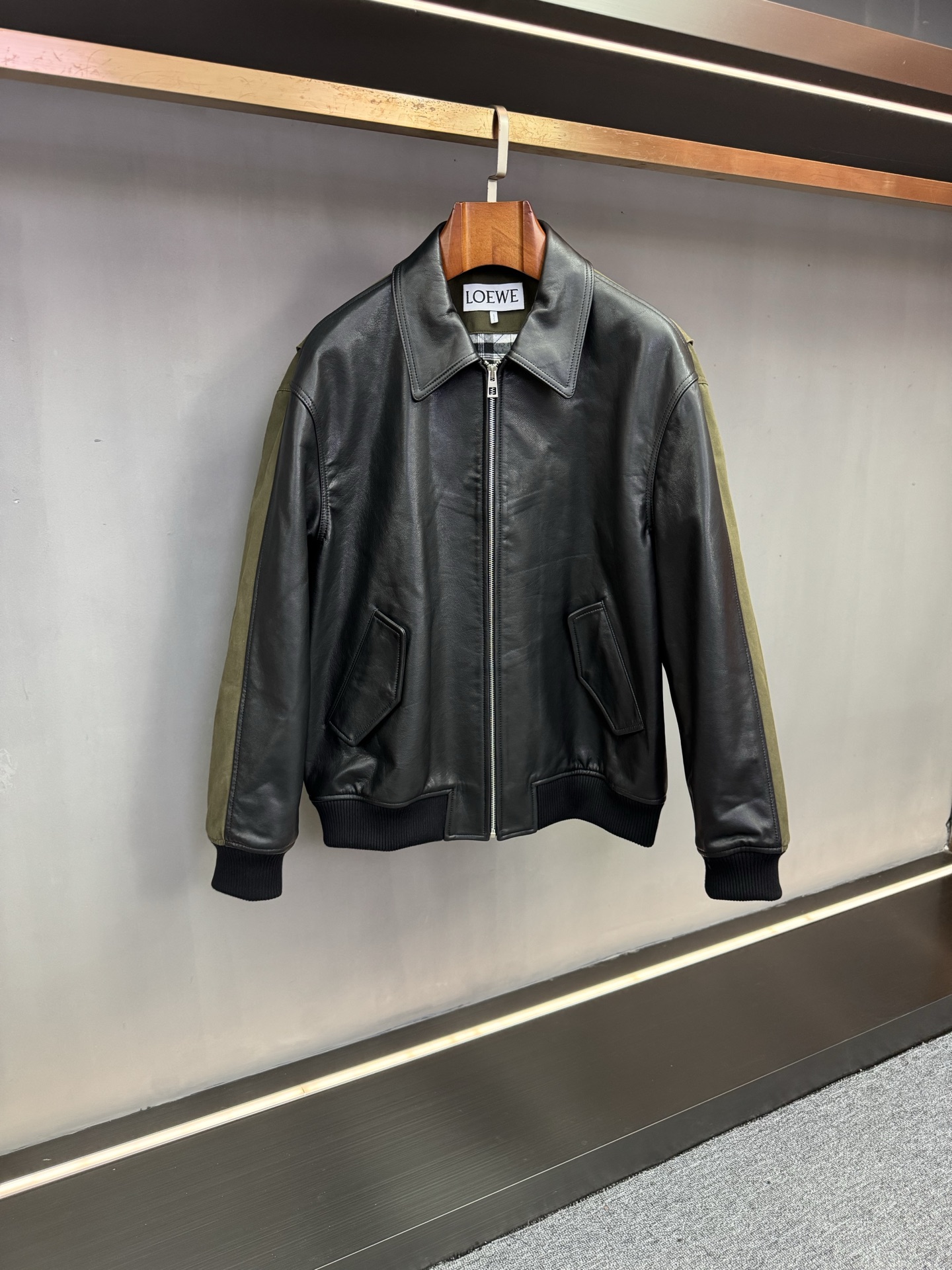 NO:772907,Loewe's 2026 spring and summer new men's cowhide splicing jacket is a high-end interpretation of craftsmanship and art. As the core item of Loewe's 2026 spring and summer men's wear series, this men's cowhide splicing jacket perfectly interprets the brand's 'radical art of restraint' and subtly integrates traditional Spanish craftsmanship with modern design aesthetics, injecting a luxurious choice of texture and style into contemporary men's autumn and winter wardrobes.  The front panel of the jacket is made of black first-layer cowhide imported from Spain, which continues the high-quality leather characteristics tempered by local tanning techniques for hundreds of years. The texture is fine and tight and retains natural pores. It feels soft and skin-friendly, and becomes more moist and shiny with time of wearing. The back panel is innovatively spliced with military green Oxford cloth, with a matte texture that has a low-key retro atmosphere and is strong.  The practical attributes of durability, lightness and breathability form a dual material and visual collision with the front cowhide, echoing the brand's iconic concept of deconstruction and reorganization. The interior adopts a classic plaid overlay design, with exquisite ingenuity hidden in the details, which not only improves the warmth and comfort when wearing, but also adds layers to the overall shape, demonstrating the luxury brand's ultimate pursuit of details.  The neat silhouette adapts to the needs of various scenes. It can bring out the elite aura in business situations, and can also show extraordinary taste in daily wear. This jacket is not only a piece of clothing, but also a concentrated interpretation of Loewe's material innovation, craft inheritance and artistic expression, highlighting the calm yet personalized dressing attitude of modern men. Size M-3XL,,loewe,loewe,jackets & coats,jackets & coats,cowhide,Top Customize119860909Loewe 罗意威2026春夏新款男士牛皮拼接外套工艺与艺术的高阶演绎 作为罗意威2026春夏男装系列的核心单品,这款男士牛皮拼接外套完美诠释品牌秉持的“激进的克制艺术”,将西班牙传统工艺与现代设计美学精妙融合,为当代男士的秋冬衣橱注入兼具质感与格调的奢华选择. 夹克前幅甄选西班牙进口黑色头层牛皮打造,延续当地百年制革工艺淬炼的优质皮革特质,纹理细腻紧实且保留天然毛孔,触感柔韧亲肤,随穿着时间沉淀愈发温润有光泽.后幅创新采用军绿色牛津布拼接,哑光质感自带低调复古气息,兼具结实耐用与轻便透气的实用属性,与前幅牛皮形成材质与视觉的双重碰撞,呼应品牌标志性的解构重组理念.内里采用经典格纹加面设计,在细节处暗藏精致巧思,既提升穿着时的保暖舒适度,又为整体造型增添层次,尽显奢侈品牌对细节的极致追求. 利落的版型适配多元场景需求,商务场合可衬显精英气场,日常穿搭亦能彰显不凡品味.这件外套不仅是一件服饰单品,更是罗意威对材质创新、工艺传承与艺术表达的集中诠释,彰显现代男性沉稳而不失个性的穿搭态度. 码数M-3XL,,loewe,loewe,jackets & coats,jackets & coats,cowhide,Top Customize1,Men's clothing