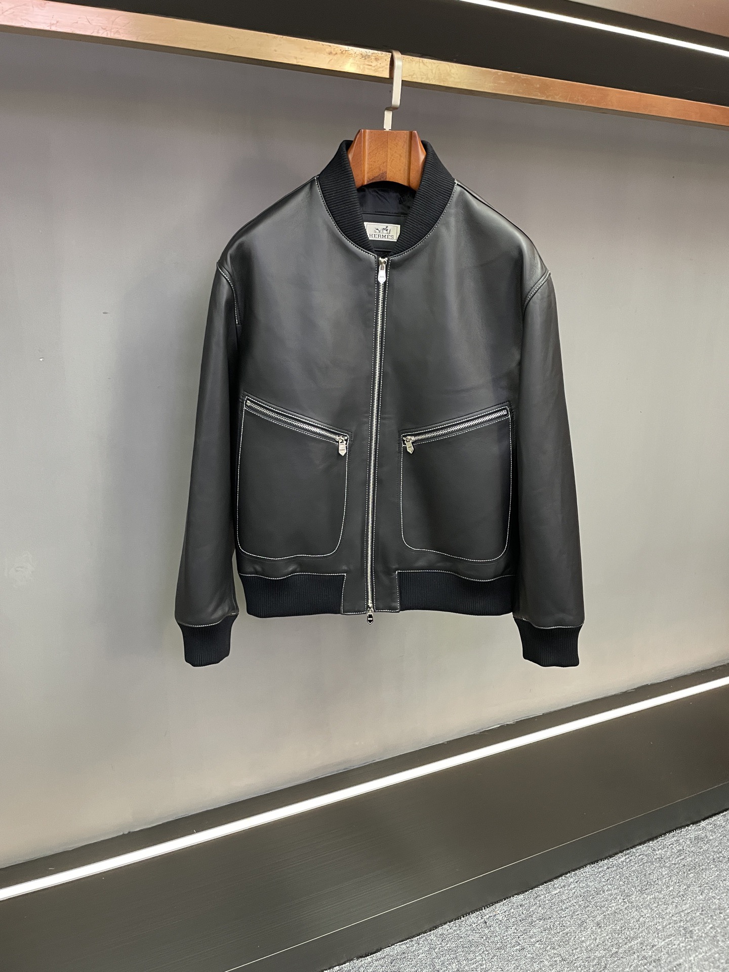 NO:772841,Hermes 2026 Spring and Summer Men's Sheepskin Jacket is an autumn and winter declaration of texture and style. When the cold weather of autumn and winter meets craftsmanship, the Hermes 2026 new men's sheepskin jacket redefines the aesthetics of gentleman's dressing with its excellent texture.  The body of the garment is made of black sheepskin imported from New Zealand, which is nourished by the unique local natural environment. The leather fiber is fine and soft, silky and warm to the touch, with a light texture and excellent warmth retention. Every inch of the texture tells the story of the extraordinary origin of the top material. The classic baseball collar design is neat and stylish, which not only retains the casual style of American retro, but also incorporates the exquisiteness of gentleman's clothing, and the neck line is more straight and neat.  Craftsmanship is evident in the details. The white stitching lines are like precise brush strokes, outlining the smooth outline of the body, forming a distinct visual hierarchy between black and white, perfectly presenting the three-dimensional texture of leather and the precise aesthetics of tailoring. From daily commuting to social occasions, this jacket has a low-key luxury style, suitable for multiple wearing scenarios, demonstrating the wearer's ultimate pursuit of quality life. Hermes 2026 new men's sheepskin jacket is based on materials, with craftsmanship as its soul, and the exquisite details hidden in it are the essential expression of high fashion.  Size M-3XL,,hermes,hermes,jackets & coats,sheepskin,Top Customize119860909Hermes 爱马仕2026春夏男士羊皮外套质感与格调的秋冬宣言 当秋冬的凛冽邂逅匠心工艺,Hermes 2026新款男士羊皮外套以卓越质感,重新定义绅士穿搭美学. 甄选新西兰进口黑色羊皮打造衣身,依托当地得天独厚的自然环境滋养,皮革纤维细密柔软,触感丝滑温润,兼具轻盈质感与出色保暖性,每一寸肌理都诉说着顶级材质的不凡出身.经典棒球领设计利落有型,既保留美式复古的随性格调,又融入绅士着装的精致感,颈间线条更显挺拔利落. 细节之处见匠心,白色车线如精准笔触,勾勒出衣身流畅轮廓,在黑白碰撞间形成鲜明视觉层次,将皮革的立体质感与剪裁的精准美学完美呈现.从日常通勤到社交场合,这件外套以低调奢华的风格,适配多元穿搭场景,彰显 wearer 对品质生活的极致追求. Hermes 2026新款男士羊皮外套,以材质为基,以工艺为魂,藏于细节的考究,正是高级时尚的本质表达. 码数 M-3XL,,hermes,hermes,jackets & coats,sheepskin,Top Customize1,Men's clothing