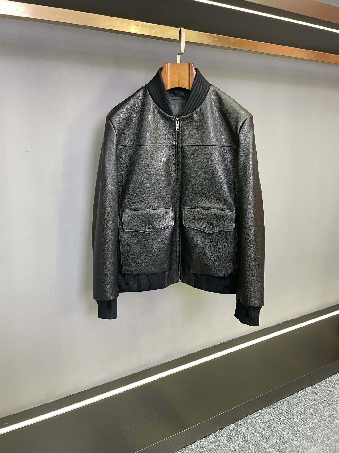 NO:772607,PRADA's 2026 spring and summer new men's cowhide jacket makes a shocking debut. Prada has never stopped on the road to pursuing excellent quality and fashion style. In the spring and summer of 2026, the new men's cowhide jacket is gloriously launched, bringing a new style to men's clothing.  This jacket is made of Spanish first-layer black calfskin, which makes it a quality choice for its top-notch texture and durability. The unique texture of the pebbled pattern not only gives the jacket a unique appearance, but also conveys an extraordinary style to the touch, highlighting the calm and elegant style of men. The simple baseball collar design finds a perfect balance between classics and fashion. It can be easily controlled whether it is a daily casual trip or a slightly formal business social occasion, showing a man's confidence and calmness.  Functionality and aesthetics are highly unified in this jacket. The multifunctional side inserts and flap pocket design not only meet the needs of daily storage of personal belongings, but also integrate into the overall shape with clever design without destroying the simple and smooth lines of the jacket. The details fully demonstrate Prada’s persistent pursuit of quality and design. Prada’s new men’s cowhide jacket is the crystallization of craftsmanship and fashion aesthetics. It is a wardrobe boutique that every man who pursues a quality life should not miss. Size 48-56,, prada, prada, jackets &  coats,cowhide,Top Customize119860909PRADA 普拉达2026春夏新款男士牛皮夹克震撼登场  在追求卓越品质与时尚风格的道路上,普拉达从未停下脚步.2026春夏,全新男士牛皮夹克荣耀面世,为男士着装带来全新风尚.  这款夹克精选西班牙头层黑色小牛皮,以其顶级的质感与耐用性,成为品质之选.荔枝纹的独特纹理,不仅赋予夹克别具一格的外观,更在触摸间传递出不凡的格调,彰显男士沉稳大气的风范.  简约棒球领设计,在经典与时尚间寻得完美平衡,无论是日常休闲出行,还是稍正式的商务社交场合,都能轻松驾驭,展现男士的自信与从容.  功能性与美观性在这款夹克上实现了高度统一.多功能侧插加揭盖口袋设计,既满足了日常存放随身物品的需求,又以巧妙的设计融入整体造型,不破坏夹克的简洁流畅线条,细节之处尽显普拉达对品质与设计的执着追求 .  Prada 新款男士牛皮夹克,是匠心工艺与时尚美学的结晶,是每位追求品质生活男士不容错过的衣橱精品. 码数 48-56,,prada,prada,jackets & coats,cowhide,Top Customize1,Men's clothing