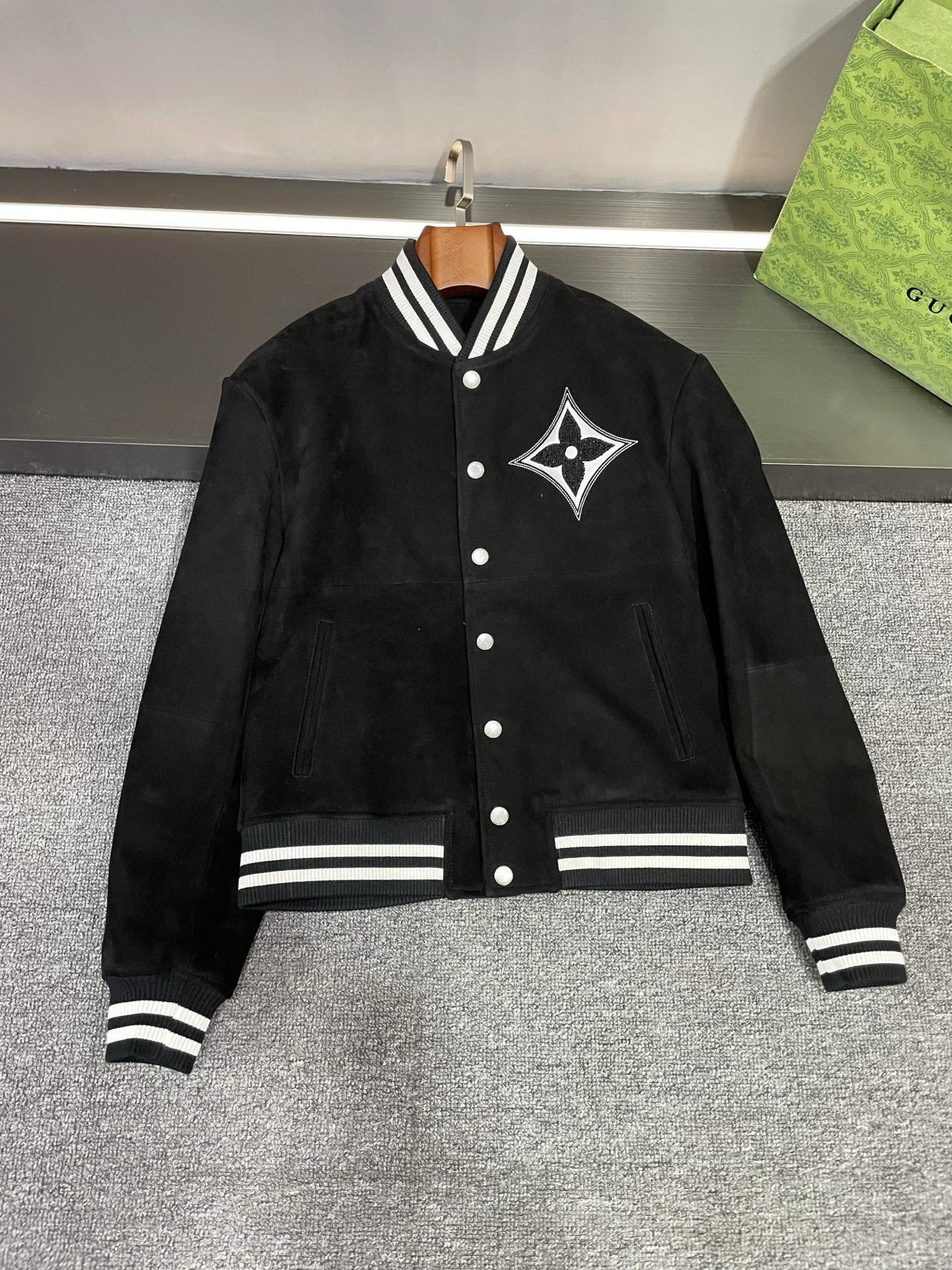 NO:772676,LV Louis Vuitton's new 2026 spring and summer men's suede sheepskin leather jacket demonstrates the ultimate in luxury and fashion!  Detailed picture of flat lay This leather jacket from Lujia is carefully made of suede black sheepskin imported from Australia. Its delicate texture is unforgettable. Every inch of leather seems to tell the brand's exquisite craftsmanship and persistent pursuit of quality. The hot diamonds and leather embroidery on the chest depict the giant Louis Vuitton LOGO, which shines brightly and instantly becomes the focus of everyone's attention. This is not only a logo, but also a symbol of fashion and taste. Look at the LV LOGO under the back collar.  Leather, low-key and luxurious, the details show the brand's sophistication and care. The pearl-engraved buttons of Louis Vuitton's latest 2026 design language add a unique charm to this leather jacket. Each button is as moist as a pearl, and the engraving technology highlights the nobility and extraordinaryness of the brand. The design of black and white contrasting threads injects fashion and vitality into the overall look. This classic color combination is both fashionable and versatile, and can show your personality and style.  Louis Vuitton has always been a leader in the fashion industry. This new men's suede sheepskin leather jacket perfectly interprets the essence of the brand. Whether it is paired with casual pants or formal wear, it can be easily worn, allowing you to exude confidence and charm in any occasion. Come and experience the fashion charm of LV!  Let this suede sheepskin leather jacket become your fashion must-have in autumn and winter, and start a journey of luxury and fashion. Size M-3XL,,louis vuitton,louis vuitton,louis vuitton,louis vuitton,leather jacket,sheepskin,Top Customize119860909LV 路易威登 2026春夏新款男士反绒羊皮皮衣,演绎极致奢华与时尚！平铺细节图  驴家这件皮衣采用澳洲进口反绒黑色羊皮精心打造,那细腻的质感,一触难忘.每一寸皮革都仿佛在诉说着品牌的精湛工艺与对品质的执着追求.  胸前的烫钻加贴皮绣,刻画出巨型 路易威登 LOGO,光芒闪耀,瞬间成为众人瞩目的焦点.这不仅仅是一个标志,更是时尚与品味的象征.  再看后衣领下方的 LV LOGO 贴皮,低调而奢华,细节之处尽显品牌的精致与用心.  路易威登2026最新设计语言的珍珠刻字纽扣,更是为这件皮衣增添了一份独特的魅力.每一颗纽扣都如同珍珠般温润,刻字工艺更是彰显了品牌的尊贵与不凡.  黑白撞色螺纹的设计,为整体造型注入了时尚与活力.这种经典的配色组合,既时尚百搭,又能展现出你的个性与风格.  路易威登一直以来都是时尚界的引领者,这件 新款男士反绒羊皮皮衣,完美地诠释了品牌的精髓.无论是搭配休闲裤还是正装,都能轻松驾驭,让你在任何场合都散发着自信与魅力.  快来感受LV的时尚魅力吧！让这件反绒羊皮皮衣成为你秋冬季节的时尚必备,开启一段奢华与时尚的旅程.  码数 M-3XL,,louis vuitton,louis vuitton,louis vuitton,louis vuitton,leather jacket,sheepskin,Top Customize1,Men's clothing