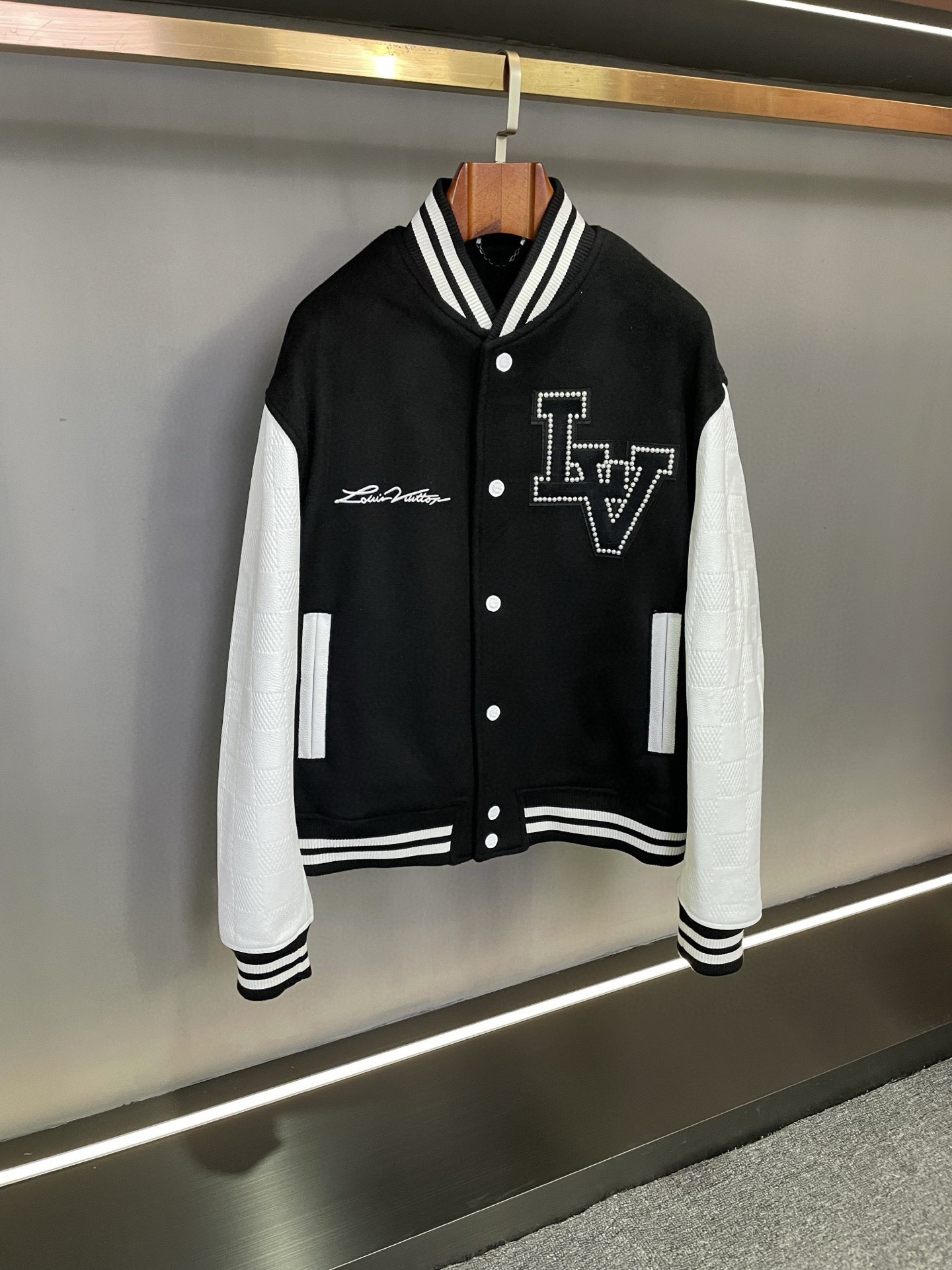 NO:772319,Louis Vuitton LV 2026 spring and summer new cowhide baseball jacket. Suitable for both men and women. Louis Vuitton's baseball jacket is really stunning at first sight and fall in love with the second. The body is made of Australian black cashmere, which is extremely soft to the touch, as if it is wrapped in warm clouds. The sleeves are Spanish first-layer white calfskin, which has a great texture and exudes a luxurious atmosphere. The black and white contrasting design of the threaded collar, hem and cuffs is classic and fashionable, adding a unique charm to the overall look.  The LV LOGO inlaid with pearls on the left chest is exquisite and elegant, exuding a charming luster. The full name of the Louis Vuitton brand is embroidered on the right chest, and the delicate craftsmanship shows the high-end quality of the brand. The brand LOGO presented in a large area of ​​embroidery on the back is even more majestic, allowing people to recognize this masterpiece from the fashion empire at a glance.  Wearing this Lvjia 2026 spring and summer new baseball uniform will bring you a stylish aura. When you walk on the street, you will be the center of attention. Size 46-54,,louis vuitton,louis vuitton,louis vuitton,louis vuitton,louis vuitton,leather jacket,cowhide,Top Customize119860909路易威登 LV 2026春夏新款牛皮棒球服皮衣.男女均可驾驭  路易威登这件棒球服真的是一眼惊艳,二眼沦陷.身子采用澳洲黑色羊绒,触感柔软至极,仿佛被温暖的云朵包裹.袖子是西班牙头层白色小牛皮,质感爆棚,散发着奢华的气息.  螺纹领子、下摆和袖口的黑白撞色设计,经典又时尚,为整体造型增添了一抹独特的魅力.  左胸前珍珠镶嵌出的 LV LOGO,精致而优雅,散发着迷人的光泽.右胸刺绣的 Louis Vuitton 品牌全称,细腻的工艺尽显品牌的高端品质.  后背大面积绣花工艺呈现的品牌 LOGO,更是大气磅礴,让人一眼就能认出这来自时尚帝国的杰作.  穿上这件驴家2026春夏新款棒球服,仿佛自带时尚光环,走在街头,你就是众人瞩目的焦点.  码数 46-54,,louis vuitton,louis vuitton,louis vuitton,louis vuitton,louis vuitton,leather jacket,cowhide,Top Customize1,Men's clothing