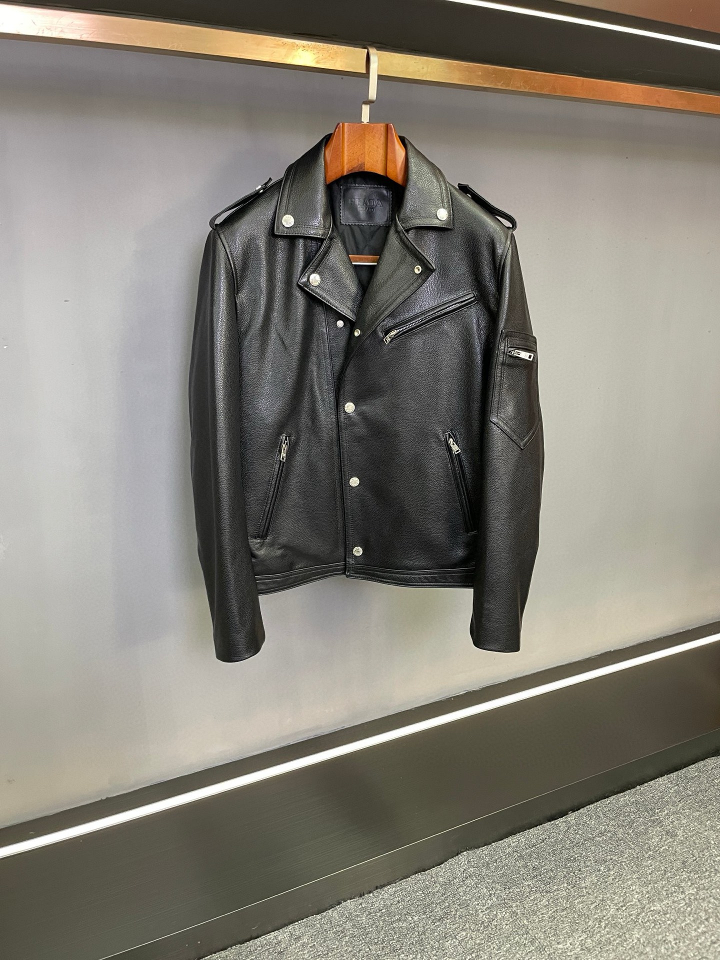 NO:773075,Prada's 2026 spring and summer new men's cowhide motorcycle jacket combines classic design with exquisite craftsmanship to interpret the stylish attitude of contemporary men.  Crafted from selected black first-layer calf leather imported from Spain, the leather surface presents a natural and delicate pebbled texture, which is rich and tough to the touch. It can accumulate a unique texture of time as it is worn. It continues the classic motorcycle suit style, and the neat lines outline a tough outline. It not only retains the unruly aura of retro motorcycle culture, but also incorporates the neatness of modern tailoring, making it easy to handle various occasions.  The thin cotton design inside brings just the right amount of warmth while avoiding bulkiness, making autumn and winter wear both warm and stylish. The details are evident, from the smooth texture of the metal zipper to the precision sewing of the seams, every detail demonstrates Prada's ultimate pursuit of quality. Prada's motorcycle jacket is both a tribute to classic style and an interpretation of pragmatism, injecting a calm and powerful outfit choice into the autumn and winter wardrobe.  Code number 48-56.,,prada,prada,cowhide,Top Customize119860909普拉达2026年春夏新款男士牛皮机车服,以经典设计碰撞精湛工艺,诠释当代男士的型格态度.  精选西班牙进口黑色头层小牛皮匠心打造,皮革表面呈现自然细腻的荔枝纹肌理,触感丰盈且富有韧性,随着穿着更能沉淀出独特的时光质感.延续经典机车服版型,利落线条勾勒出硬朗轮廓,既保留了复古机车文化的不羁气场,又融入现代剪裁的利落感,轻松驾驭多元场合.  内里添加薄棉设计,在带来恰到好处保暖性的同时,避免了臃肿感,让秋冬穿着兼具温度与型格.细节之处见真章,从金属拉链的顺滑质感,到接缝处的精密缝制,每一处都彰显着普拉达对品质的极致追求.  普拉达 Prada 这款机车服,既是对经典风格的致敬,也是对实用主义的诠释,为秋冬衣橱注入沉稳而富有力量的穿搭选择. 码数48-56.,,prada,prada,cowhide,Top Customize1,Men's clothing