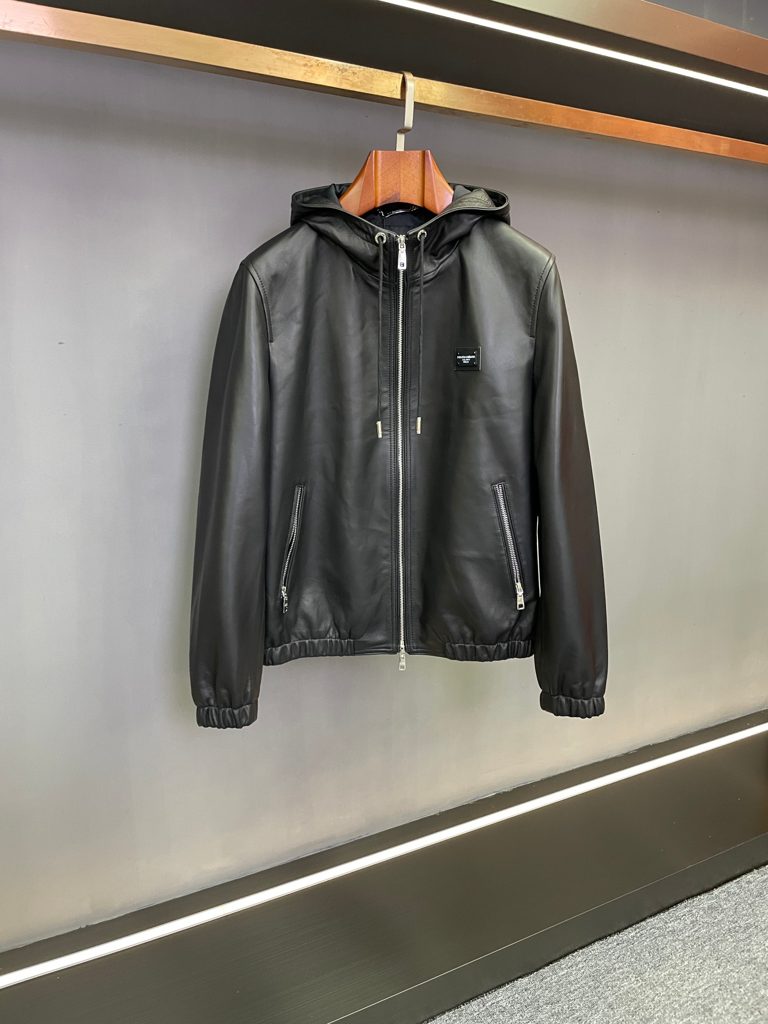 NO:772104,D&G Dolce & Gabbana 2026 Spring and Summer Sheepskin Jacket has Italian style and relaxed texture. Dolce & Gabbana's 2026 Spring and Summer Men's Series uses black sheepskin imported from New Zealand to create a hooded jacket, integrating Italian luxury into daily wear, showing a low-key and refined style. The core texture of the sheepskin is delicate and has an extraordinary touch.  Selected black sheepskin imported from New Zealand has a soft yet stiff texture, and the matte texture has a high-end luster. It has a warm and moist touch that is within reach. It has been polished with ingenious craftsmanship and the texture is revealed over time. It perfectly meets the lightness of spring and summer and the need for warmth in autumn and winter. The design is ingenious with a hooded version, and the details are the finishing touch.  The classic hooded style, the drawstring design can be freely adjusted, casual and windproof. The neat lines modify the body shape, and it can be worn open for a relaxed holiday style. The zipper turns it into a sophisticated commuter outfit in an instant, making it very practical to wear multiple clothes. The D&G metal nameplate on the left chest is the finishing touch, and the brand logo is low-key. The metallic luster and sheepskin texture complement each other, and the brand's ingenuity is shown in every detail. The outfit is suitable for all seasons and is suitable for all seasons.  The black color is versatile and not fussy, and the white T underneath is refreshing and casual. Pair it with jeans for a yuppie casual style; wear it with trousers for a light business style. Whether it is for outings in spring, light travel in summer, or layering in autumn and winter, this jacket can be easily held in place, becoming a high-quality item in the wardrobe that combines both style and practicality.  With century-old Italian aesthetics, Dolce & Gabbana perfectly integrates materials, styles and details to present contemporary men with new spring and summer dressing options. You can pick up the high-end style as soon as you start~ Size M-3XL,,Dolce&Gabbana,Dolce&Gabbana,jeans,jackets & coats,sheepskin,hats,Top Customize119860909D&G 杜嘉班纳2026春夏羊皮夹克意式格调,松弛质感  杜嘉班纳2026春夏男士系列,以新西兰进口黑色羊皮打造连帽夹克,将意式奢华融入日常穿搭,尽显低调精致的型格.  核心质感细腻羊皮,触感非凡  精选新西兰进口黑色羊皮,质地柔软却不失挺括,哑光肌理自带高级光泽.触手可及的温润触感,历经匠心工艺打磨,越穿越显质感,完美契合春夏轻盈调性与秋冬保暖需求.  设计巧思连帽版型,细节点睛  经典连帽版型,抽绳设计可自由调节,随性松弛又防风.利落线条修饰身形,敞开穿是松弛度假风,拉合拉链秒变精致通勤装,一衣多穿超实用.左胸D&G金属铭牌是点睛之笔,品牌标识低调彰显,金属光泽与羊皮纹理相映成趣,细节处尽显品牌匠心.  穿搭适配格调拉满,四季皆宜  黑色百搭不挑人,内搭白T清爽随性,配牛仔裤是雅痞休闲风；搭西裤则秒升轻商务格调.无论是春日踏青、夏日轻出行,还是秋冬叠穿,这款夹克都能轻松hold住,成为衣橱中格调与实穿兼备的质感单品.  杜嘉班纳以百年意式美学,将材质、版型与细节完美融合,为当代男士呈现春夏穿搭新选择,入手即拿捏高阶格调～ 码数M-3XL,,Dolce&Gabbana,Dolce&Gabbana,jeans,jackets & coats,sheepskin,hats,Top Customize1,Men's clothing