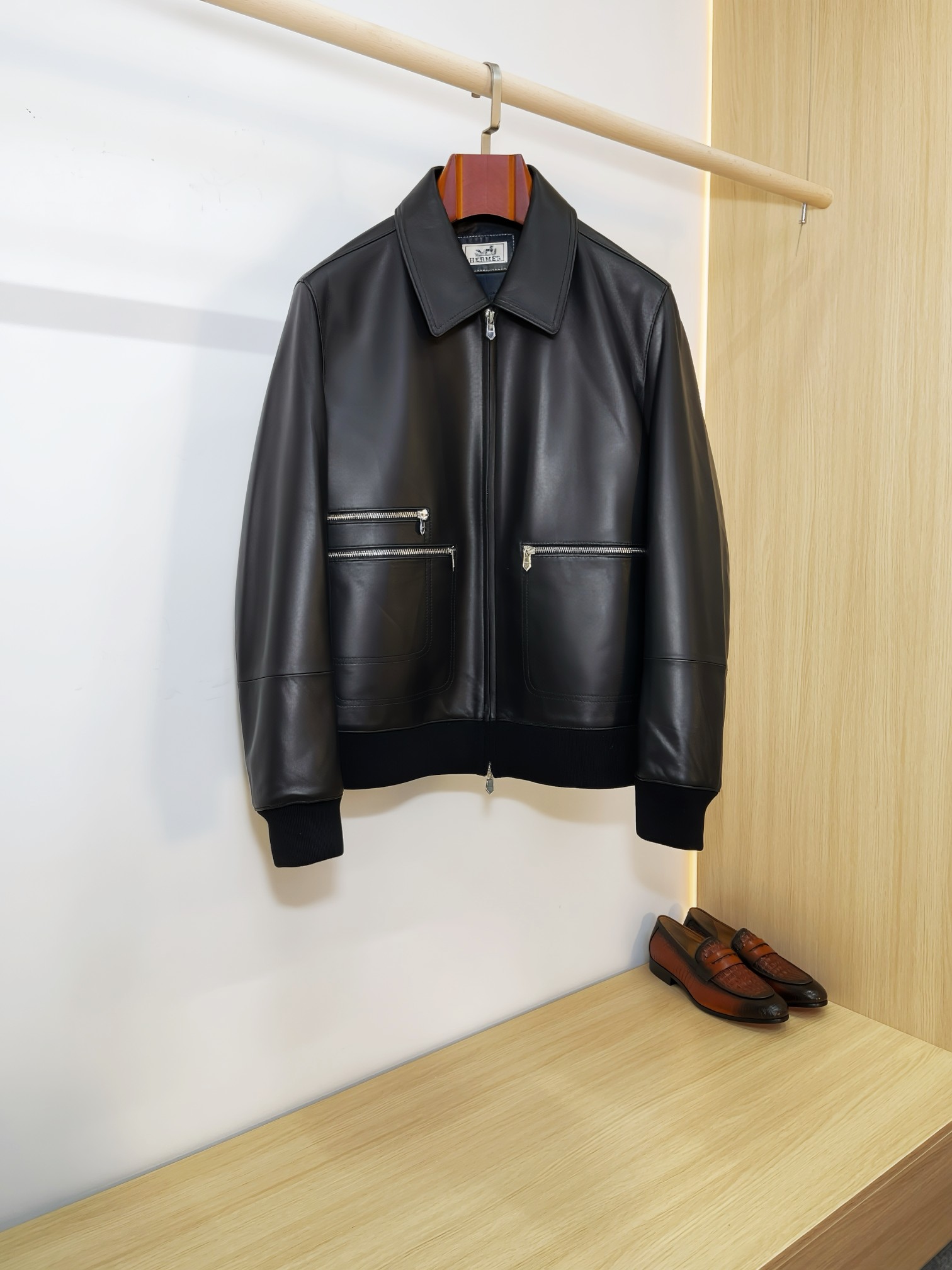 NO:940566,Hermès minimalist lapel sheepskin bomber jacket Hermès classic casual leather jacket, minimalist and neat lapel baseball jacket style, regardless of body shape or outfit, can be used for business commuting, daily leisure, and motorcycle style. Imported first-layer sheepskin is selected, the leather surface is delicate, soft and has a soft light texture. It is soft and skin-friendly and has high toughness. It is not easy to get hard and wrinkle after long-term wear.  The neat full-zipper placket and multiple zipper cargo pockets on the front are both decorative and practical. The hardware details are matte and high-end, low-key and not exaggerated; the hem + ribbed cuffs, the classic baseball uniform structure, firmly locks the shape, and the upper body looks slim and neat, without being bulky and dragging.  The lining is custom-made with a smooth and skin-friendly lining, and the stitching is neat and precise. The entire garment is clean and smooth with no redundant design, which perfectly interprets Hermès' 'less is more' top-notch luxury aesthetics. Available in black and white, black is calm and elegant, and off-white is clean and elegant. A men's wardrobe that has been worn for many years and will never go out of style just needs hard goods, and the light luxury texture can be filled directly. Size M-3XL,,hermes,hermes,jackets & coats,leather jacket,sheepskin,Top  Customize119860909爱马仕 Hermès极简翻领羊皮飞行员夹克  爱马仕经典休闲皮衣天花板,极简利落的翻领棒球夹克版型,不挑身材不挑穿搭,商务通勤、日常休闲、轻机车风全能驾驭.  甄选进口头层绵羊皮,皮面细腻柔润自带柔光质感,软糯亲肤同时韧性十足,久穿不易发硬起皱. 利落全开拉链门襟,前身多拉链工装口袋,兼具装饰性与实用性,五金细节哑光高级,低调不浮夸；下摆+罗纹收口袖口,经典棒球服结构,牢牢锁住版型,上身显瘦利落,不臃肿拖沓.  内里定制顺滑亲肤里布,走线工整精密,整件衣服剪裁干净流畅,没有多余冗余设计,完美诠释爱马仕「少即是多」的顶级轻奢美学. 黑白双色可选沉稳黑低调显贵,米白干净儒雅,一件穿多年,永不过时的男士衣橱刚需硬货,轻奢质感直接拉满. 码数M-3XL,,hermes,hermes,jackets & coats,leather jacket,sheepskin,Top Customize1,Men's clothing