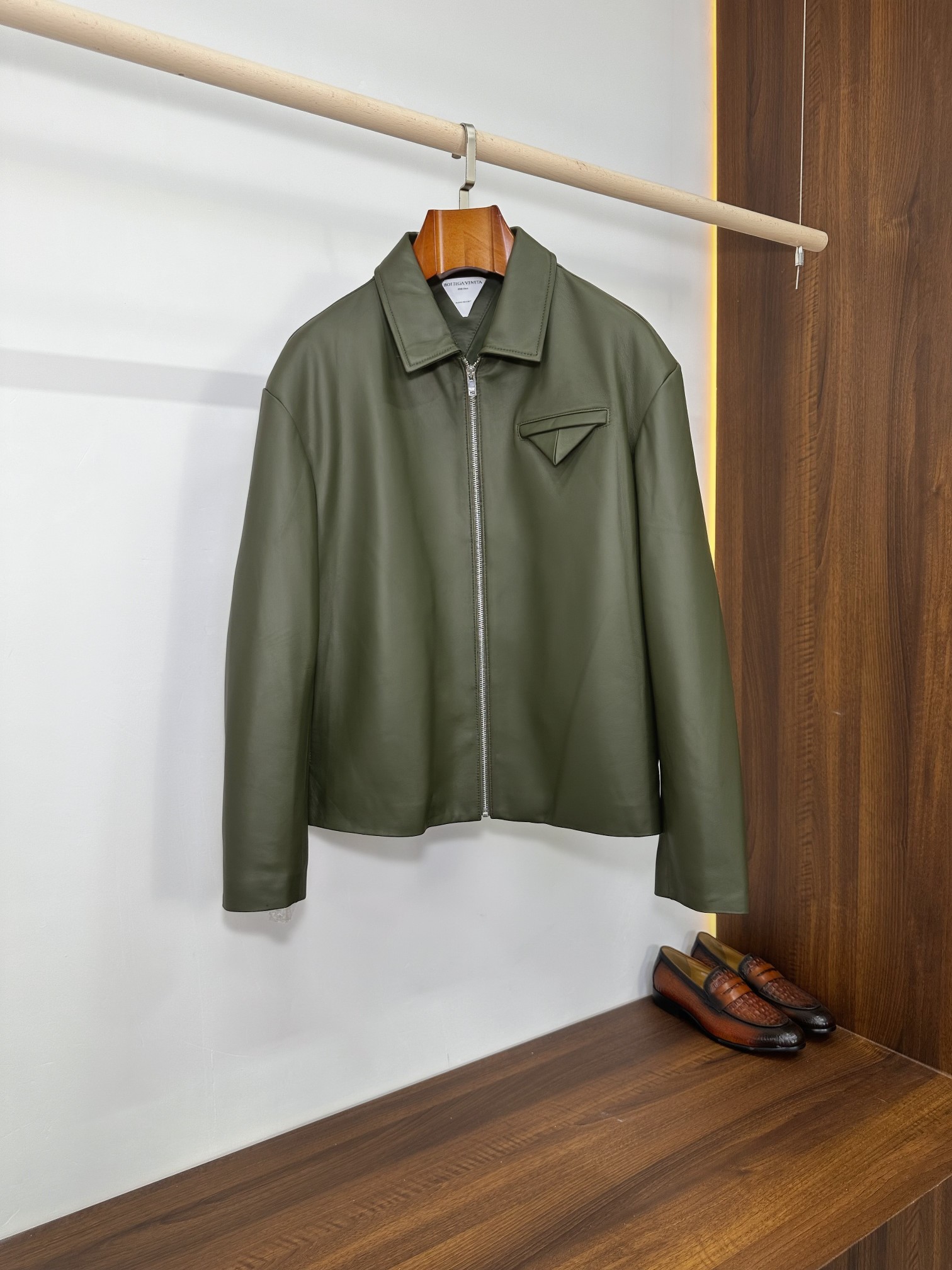 NO:940440,Bottega Veneta Army Green Lapel Sheepskin Short Jacket | Italian Minimalist Ceiling Bottega Veneta's most iconic logo-less minimalist aesthetic, this solid-color lapel sheepskin jacket brings a low-key sense of luxury to the extreme. It is made of imported fine lambskin, which is soft and skin-friendly and has a matte and smooth texture. It is available in dark green and black colors. It is a basic leather hard item that will never go out of style in the light luxury men's wardrobe. Core advantages of fabrics  The whole body is made of high-grade imported lambskin. The leather is fine and pliable, and feels smooth and waxy. It will not be as tight as hard cowhide, and will not restrict daily activities. The matte matte solid color texture, without redundant printing or exaggerated logos, relies entirely on the fineness of the leather itself to reflect the luxury grade; the leather is solid, windproof and breathable, and is not easy to crack and peel after long-term wear. As it is worn, it gradually develops a natural warm luster, giving it a more textured look. Tailoring and detailed design  The neat small lapels, straight zipper placket, short fitted length, accurately optimize body proportions, raise the waistline and modify the body shape, and can be easily controlled by men of small stature and broad shoulders. The iconic triangular three-dimensional patch pocket on the chest is a classic minimalist structural design of BV, which is simple but highly brand-recognizable. It abandons superfluous decoration and uses three-dimensional tailoring to highlight the atmosphere of high-end workwear.  The triangular cutting line on the back strengthens the three-dimensional stiffness of the body and will not sag against the back; the cuffs are straight and trimmed, the lines are neat and precise, and the whole garment is invisible sewing technology, which is low-key and restrained. The interior is matched with a customized smooth lining of the same color, which is silky smooth and non-abrasive when put on and taken off. It can be worn alone in spring and autumn casually and relaxedly. In winter, it is suitable for cashmere sweaters, turtleneck bases, and shirts, and the layering effect is clean and neat. Size 48-56, Bottega  veneta,bottega veneta,bottega veneta,jackets & coats,jackets & coats,shirts,cowhide,sheepskin,Top Customize119860909Bottega Veneta 军绿翻领羊皮短夹克｜意式极简天花板  葆蝶家最标志性的无logo极简美学,这件纯色翻领羊皮外套把低调高级感发挥到极致,甄选进口细腻小羊皮打造,软糯亲肤且自带哑光柔润肌理,墨绿、黑色双配色可选,是轻奢男士衣柜里永不过时的基础真皮硬货.  面料核心优势  通体采用高等级进口小羊皮,皮质细腻柔韧,手感顺滑软糯,不会像硬牛皮那样紧绷压身,日常活动零束缚.哑光雾面纯色质感,无多余印花、浮夸标识,完全依靠皮料本身的细腻度体现奢华品级；皮质密度扎实,防风透气,久穿不易开裂起皮,随着穿着慢慢形成自然温润光泽,越穿越有质感.  剪裁与细节设计  利落小翻领直拉拉链开襟,短款合身衣长,精准优化身材比例,拉高腰线、修饰身形,小个子、宽肩男士都能轻松驾驭.胸口标志性三角立体贴袋,是BV经典极简结构设计,简约却极具品牌辨识度,摒弃多余装饰,用立体剪裁凸显高级工装氛围感. 后背三角分割裁线,强化衣身立体挺括度,不会软塌贴背；袖口平直收边,走线工整精密,全衣隐形车缝工艺,低调内敛.内里搭配同色系定制顺滑里布,穿脱丝滑不磨肤,春秋单穿随性松弛,冬季内搭羊绒衫、高领打底、衬衫都适配,叠穿层次感干净利落. 码数48-56,,bottega veneta,bottega veneta,bottega veneta,jackets & coats,jackets & coats,shirts,cowhide,sheepskin,Top Customize1,Men's clothing