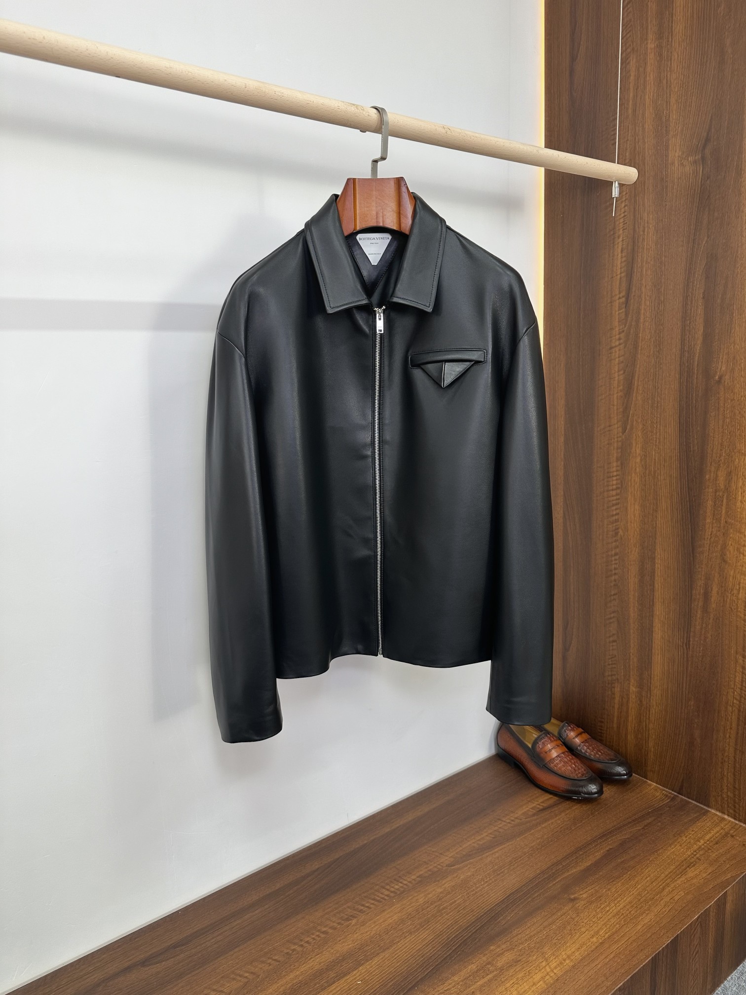 NO:940452,Bottega Veneta Army Green Lapel Sheepskin Short Jacket | Italian Minimalist Ceiling Bottega Veneta's most iconic logo-less minimalist aesthetic, this solid-color lapel sheepskin jacket brings a low-key sense of luxury to the extreme. It is made of imported fine lambskin, which is soft and skin-friendly and has a matte and smooth texture. It is available in dark green and black colors. It is a basic leather hard item that will never go out of style in the light luxury men's wardrobe. Core advantages of fabrics  The whole body is made of high-grade imported lambskin. The leather is fine and pliable, and feels smooth and waxy. It will not be as tight as hard cowhide, and will not restrict daily activities. The matte matte solid color texture, without redundant printing or exaggerated logos, relies entirely on the fineness of the leather itself to reflect the luxury grade; the leather is solid, windproof and breathable, and is not easy to crack and peel after long-term wear. As it is worn, it gradually develops a natural warm luster, giving it a more textured look. Tailoring and detailed design  The neat small lapels, straight zipper placket, short fitted length, accurately optimize body proportions, raise the waistline and modify the body shape, and can be easily controlled by men with short and broad shoulders. The iconic triangular three-dimensional patch pocket on the chest is a classic minimalist structural design of BV, which is simple but highly brand-recognizable. It abandons superfluous decoration and uses three-dimensional tailoring to highlight the atmosphere of high-end workwear.  The triangular cutting line on the back strengthens the three-dimensional stiffness of the body and will not sag against the back; the cuffs are straight and trimmed, the lines are neat and precise, and the whole garment is invisible sewing technology, which is low-key and restrained. The interior is matched with a customized smooth lining of the same color, which is silky smooth and non-abrasive when put on and taken off. It can be worn alone in spring and autumn casually and relaxedly. In winter, it is suitable for cashmere sweaters, turtleneck bases, and shirts, and the layering effect is clean and neat. Size 48-56, Bottega  veneta,bottega veneta,bottega veneta,jackets & coats,jackets & coats,shirts,cowhide,sheepskin,Top Customize119860909Bottega Veneta 军绿翻领羊皮短夹克｜意式极简天花板  葆蝶家最标志性的无logo极简美学,这件纯色翻领羊皮外套把低调高级感发挥到极致,甄选进口细腻小羊皮打造,软糯亲肤且自带哑光柔润肌理,墨绿、黑色双配色可选,是轻奢男士衣柜里永不过时的基础真皮硬货.  面料核心优势  通体采用高等级进口小羊皮,皮质细腻柔韧,手感顺滑软糯,不会像硬牛皮那样紧绷压身,日常活动零束缚.哑光雾面纯色质感,无多余印花、浮夸标识,完全依靠皮料本身的细腻度体现奢华品级；皮质密度扎实,防风透气,久穿不易开裂起皮,随着穿着慢慢形成自然温润光泽,越穿越有质感.  剪裁与细节设计  利落小翻领直拉拉链开襟,短款合身衣长,精准优化身材比例,拉高腰线、修饰身形,小个子、宽肩男士都能轻松驾驭.胸口标志性三角立体贴袋,是BV经典极简结构设计,简约却极具品牌辨识度,摒弃多余装饰,用立体剪裁凸显高级工装氛围感. 后背三角分割裁线,强化衣身立体挺括度,不会软塌贴背；袖口平直收边,走线工整精密,全衣隐形车缝工艺,低调内敛.内里搭配同色系定制顺滑里布,穿脱丝滑不磨肤,春秋单穿随性松弛,冬季内搭羊绒衫、高领打底、衬衫都适配,叠穿层次感干净利落. 码数48-56,,bottega veneta,bottega veneta,bottega veneta,jackets & coats,jackets & coats,shirts,cowhide,sheepskin,Top Customize1,Men's clothing