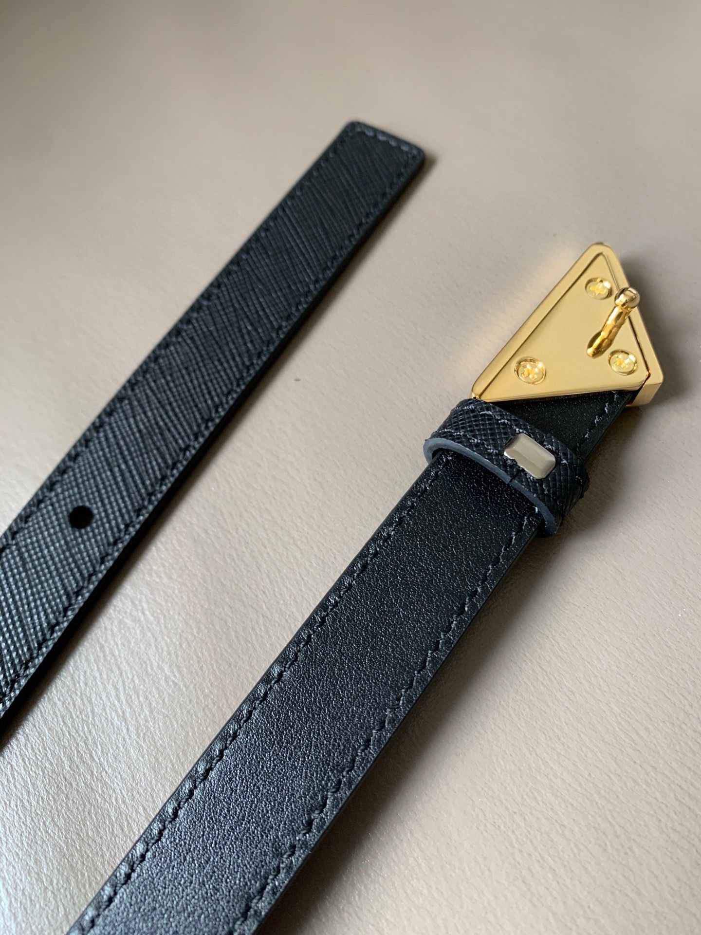 Prada(普拉达) 专柜新款 宽2.0cm 这款腰带设计简约而不失精美。金属搭扣呈现标志性的三角形徽标