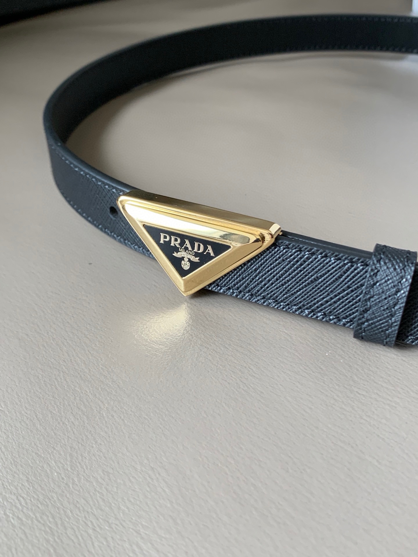 Prada(普拉达) 专柜新款 宽2.0cm 这款腰带设计简约而不失精美。金属搭扣呈现标志性的三角形徽标