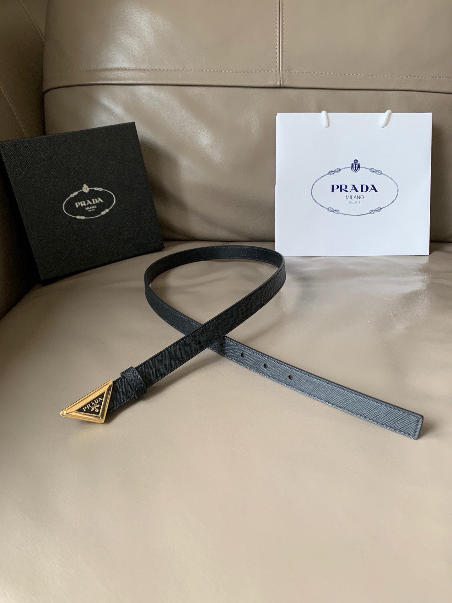 Prada(普拉达) 专柜新款 宽2.0cm 这款腰带设计简约而不失精美。金属搭扣呈现标志性的三角形徽标