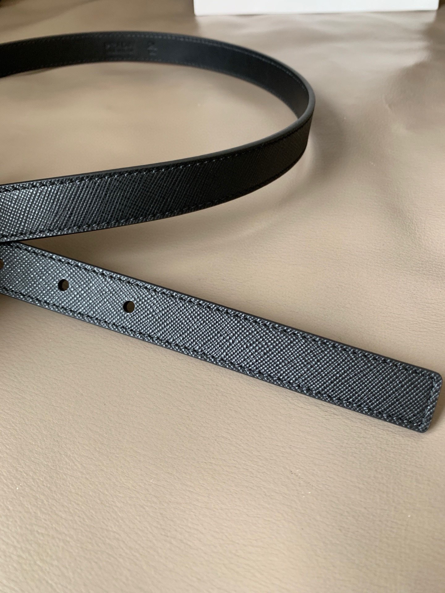 Prada(普拉达) 专柜新款 宽2.0cm 这款腰带设计简约而不失精美。金属搭扣呈现标志性的三角形徽标