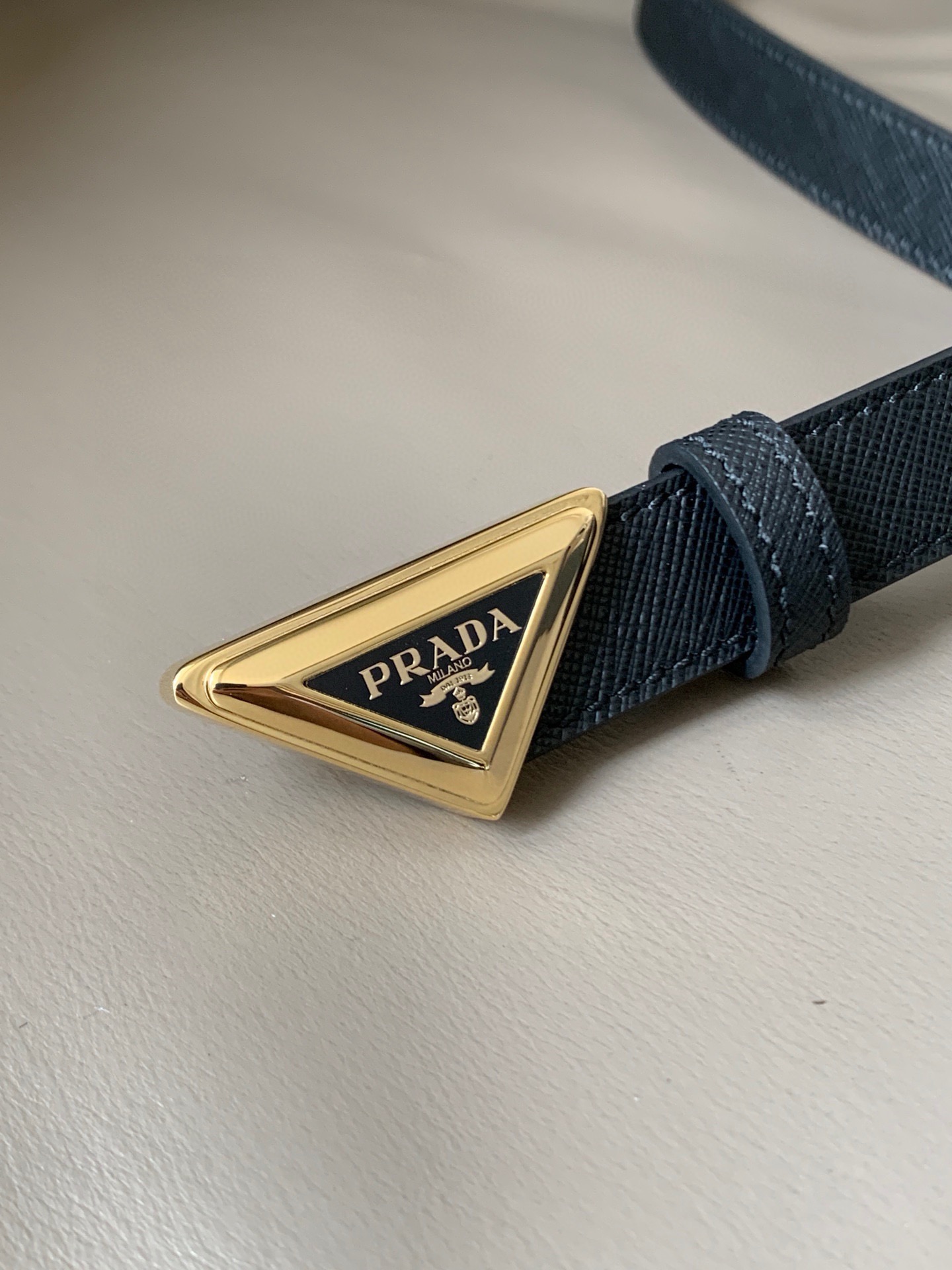 Prada(普拉达) 专柜新款 宽2.0cm 这款腰带设计简约而不失精美。金属搭扣呈现标志性的三角形徽标