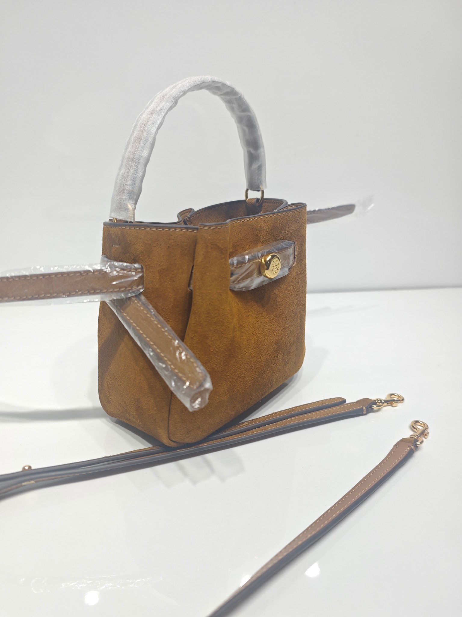 原单P380
❤️迷你miniTB新款 Romy 水桶包，精选柔软皮革，廓形灵巧，顶部巧妙收拢，富有质感。这款水桶包适合日常出行使用，轻盈灵活，包内空间宽敞，贴心配备一个口袋，方便有序收纳。配有纤细背带，并融入全新纽扣式 Logo，增添时尚亮点。可手提或斜挎，满足多样穿搭需求。磁力按扣；背带设有钉扣
尺寸18&times;8&times;15
编号179988