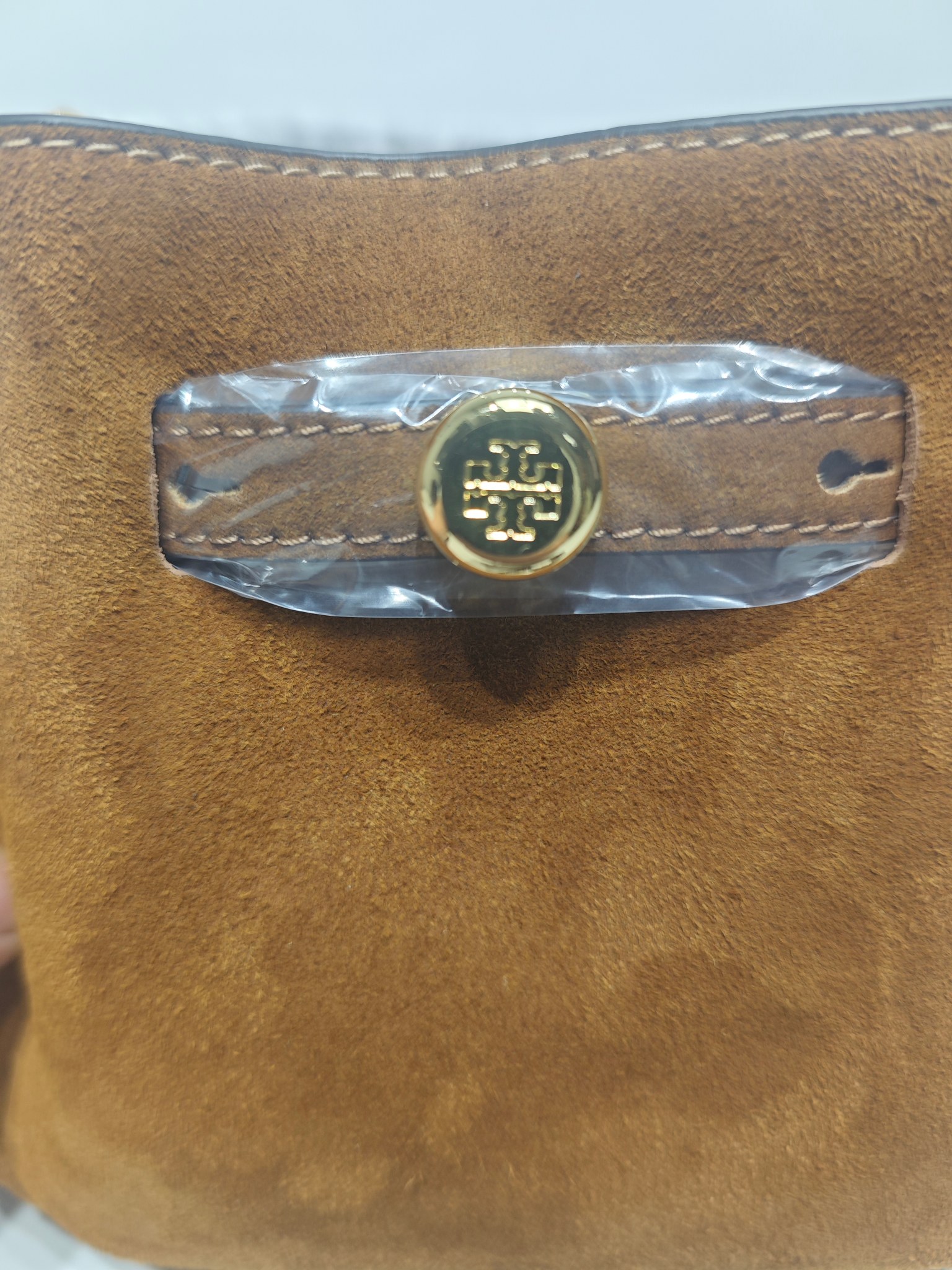 原单P380
❤️迷你miniTB新款 Romy 水桶包，精选柔软皮革，廓形灵巧，顶部巧妙收拢，富有质感。这款水桶包适合日常出行使用，轻盈灵活，包内空间宽敞，贴心配备一个口袋，方便有序收纳。配有纤细背带，并融入全新纽扣式 Logo，增添时尚亮点。可手提或斜挎，满足多样穿搭需求。磁力按扣；背带设有钉扣
尺寸18&times;8&times;15
编号179988