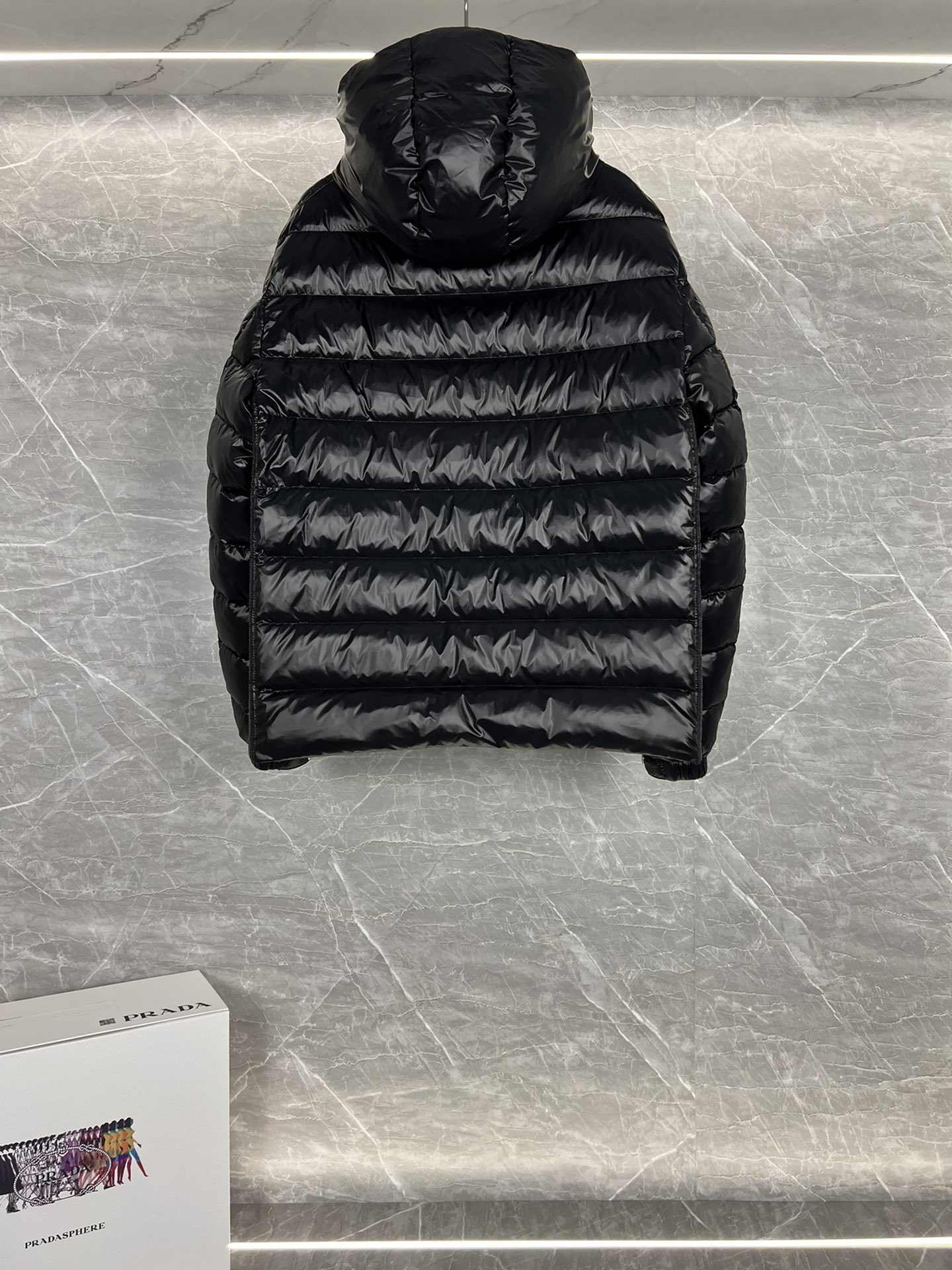 Prada hooded down jacket with oversized fit, quilted design, 90% down fill, enamel triangle logo. Sizes 48-56 in black/blue.-Big cat