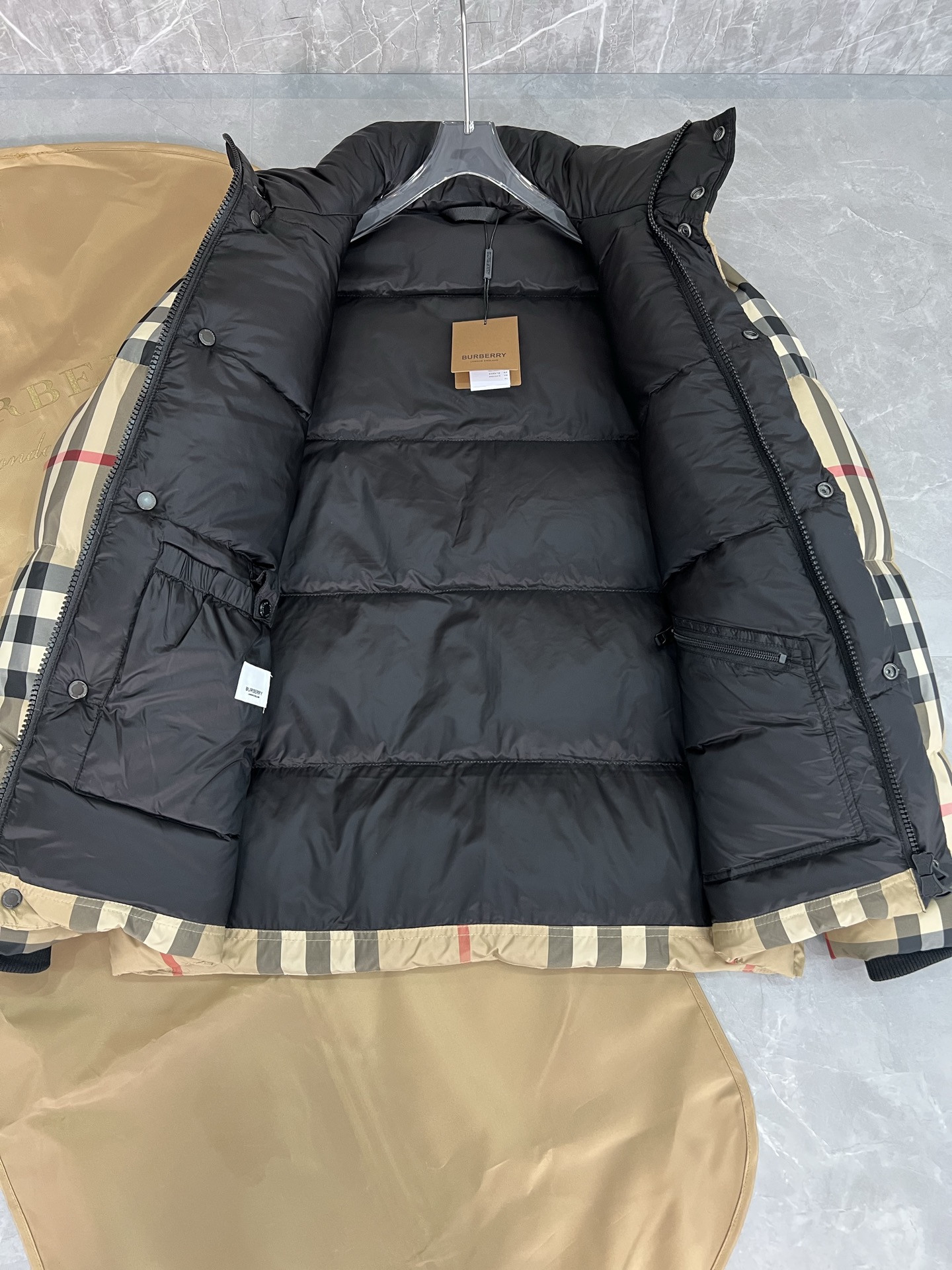 Guangzhou high-end Burberry down jacket for Winter 2025. Premium version with iconic check pattern, warm yet lightweight. Features high collar, removable hood with faux fur. Available in versatile colors, sizes M to XXXL. Limited stock.-Big cat