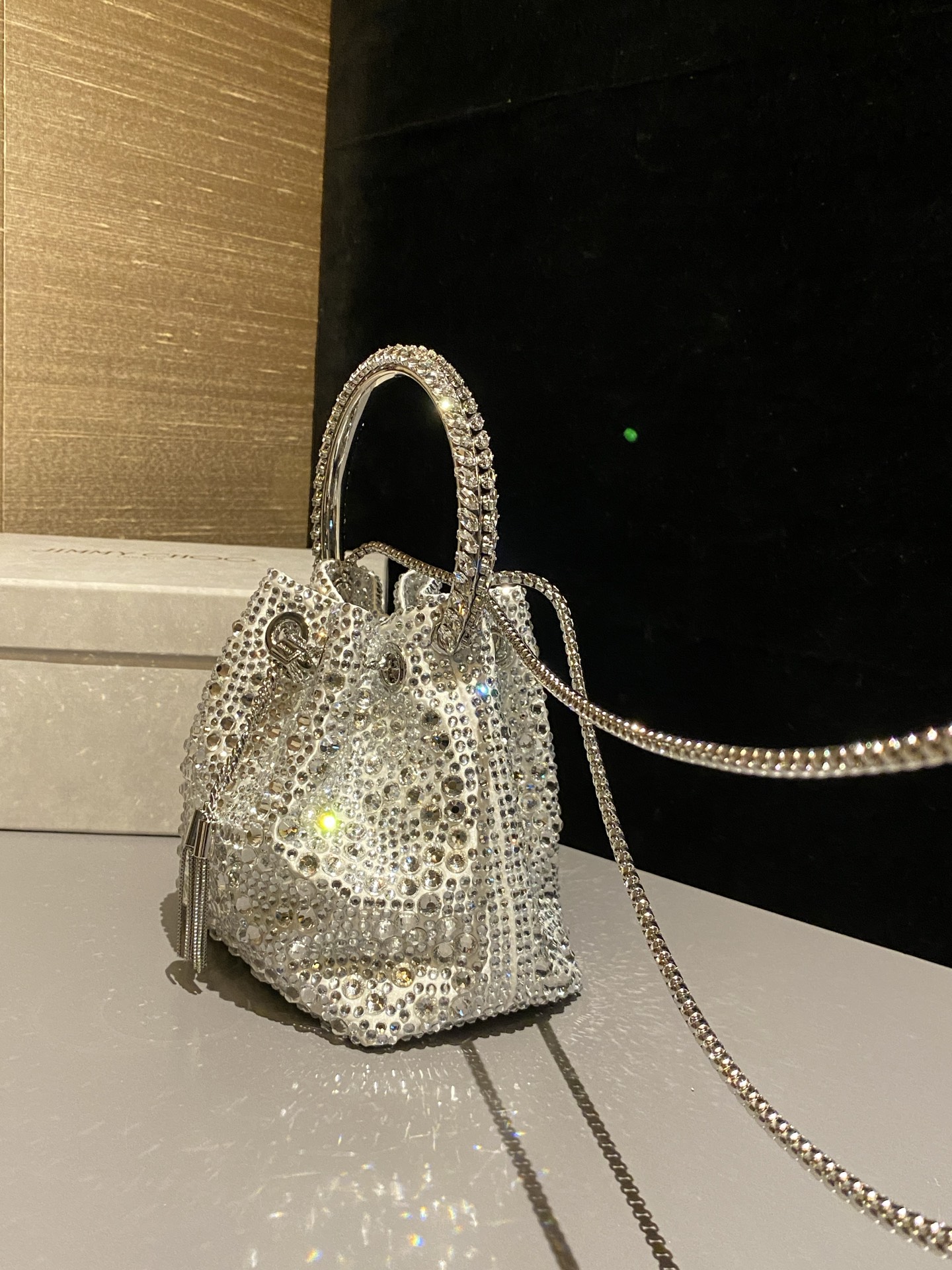 JIMMY CHOO
BON BON系列标志款手提包,光滑缎面铺嵌渐变水晶制作。
设计灵感源于软硬质感及甜美与张扬气质的强烈对比,点睛配以标志性金属流苏,成就如BON BON之名般个性别致又优雅迷人的时尚包袋。现代感桶包廓形,配以手环造型顶部提手,提手饰有百粒经三天精工颗颗细嵌的水晶,精美雅致,招牌奢华包袋当属本款BON BON手提包。
缎面烫钻水晶手嵌水晶饰手环提手Jimmy Choo logo压印金属流苏开合链条肩带内层口袋包袋尺寸:16(长)x15(高)x9.5(宽)厘米肩带长度:55厘米提手长度:9厘米 20259