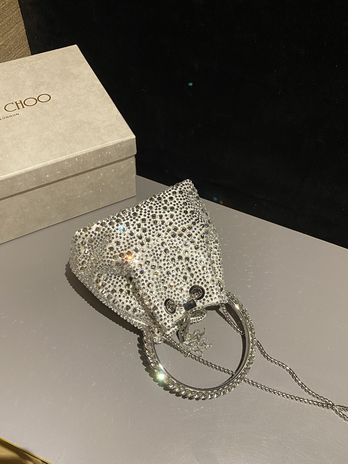 JIMMY CHOO
BON BON系列标志款手提包,光滑缎面铺嵌渐变水晶制作。
设计灵感源于软硬质感及甜美与张扬气质的强烈对比,点睛配以标志性金属流苏,成就如BON BON之名般个性别致又优雅迷人的时尚包袋。现代感桶包廓形,配以手环造型顶部提手,提手饰有百粒经三天精工颗颗细嵌的水晶,精美雅致,招牌奢华包袋当属本款BON BON手提包。
缎面烫钻水晶手嵌水晶饰手环提手Jimmy Choo logo压印金属流苏开合链条肩带内层口袋包袋尺寸:16(长)x15(高)x9.5(宽)厘米肩带长度:55厘米提手长度:9厘米 20259