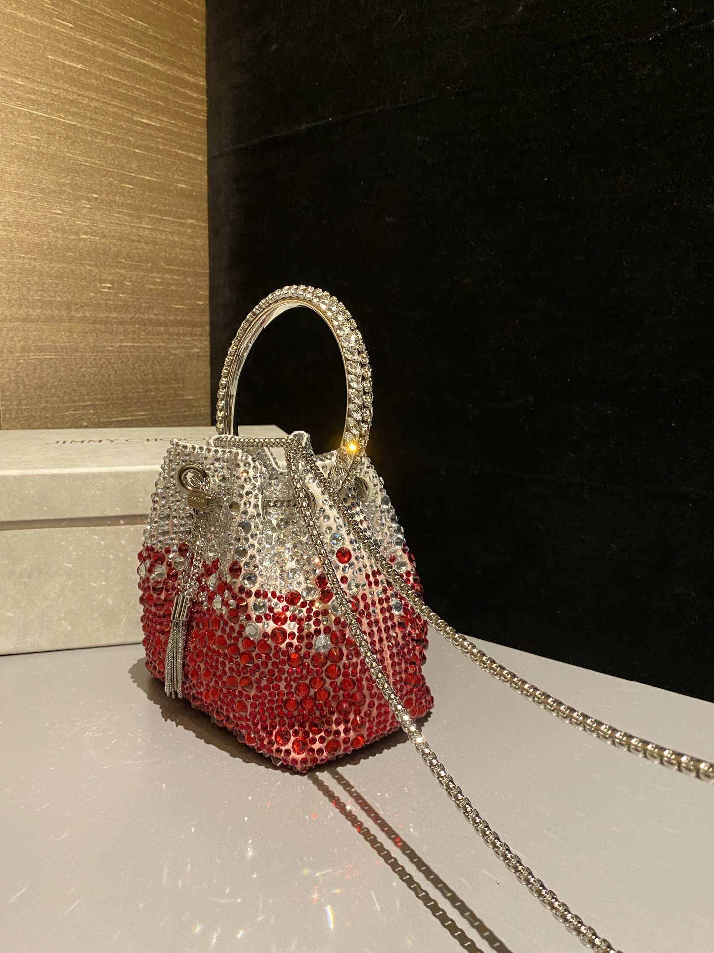JIMMY CHOO
BON BON系列标志款手提包,光滑缎面铺嵌渐变水晶制作。
设计灵感源于软硬质感及甜美与张扬气质的强烈对比,点睛配以标志性金属流苏,成就如BON BON之名般个性别致又优雅迷人的时尚包袋。现代感桶包廓形,配以手环造型顶部提手,提手饰有百粒经三天精工颗颗细嵌的水晶,精美雅致,招牌奢华包袋当属本款BON BON手提包。
缎面烫钻水晶手嵌水晶饰手环提手Jimmy Choo logo压印金属流苏开合链条肩带内层口袋包袋尺寸:16(长)x15(高)x9.5(宽)厘米肩带长度:55厘米提手长度:9厘米 20259