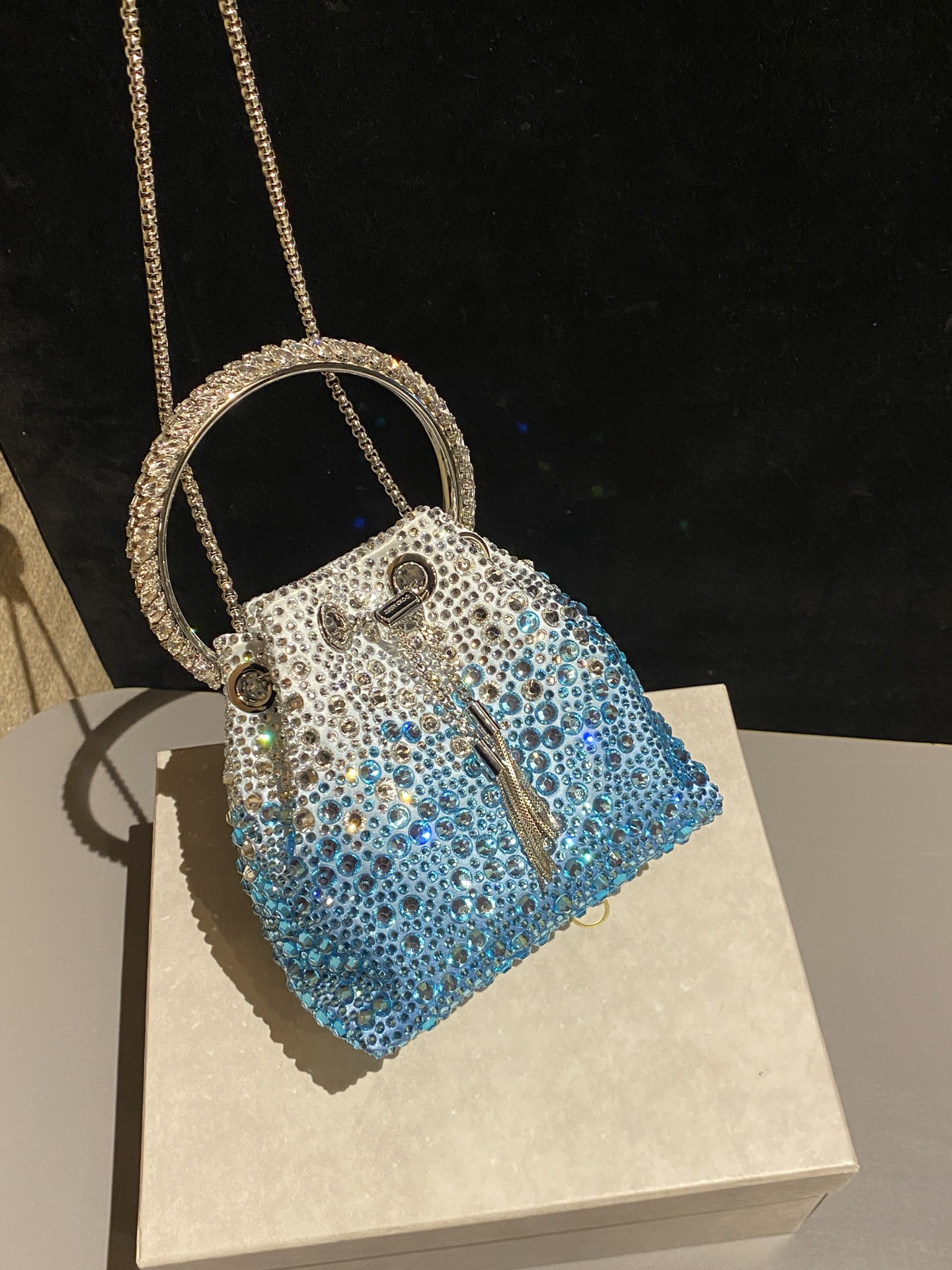 JIMMY CHOO
BON BON系列标志款手提包,光滑缎面铺嵌渐变水晶制作。
设计灵感源于软硬质感及甜美与张扬气质的强烈对比,点睛配以标志性金属流苏,成就如BON BON之名般个性别致又优雅迷人的时尚包袋。现代感桶包廓形,配以手环造型顶部提手,提手饰有百粒经三天精工颗颗细嵌的水晶,精美雅致,招牌奢华包袋当属本款BON BON手提包。
缎面烫钻水晶手嵌水晶饰手环提手Jimmy Choo logo压印金属流苏开合链条肩带内层口袋包袋尺寸:16(长)x15(高)x9.5(宽)厘米肩带长度:55厘米提手长度:9厘米 20259