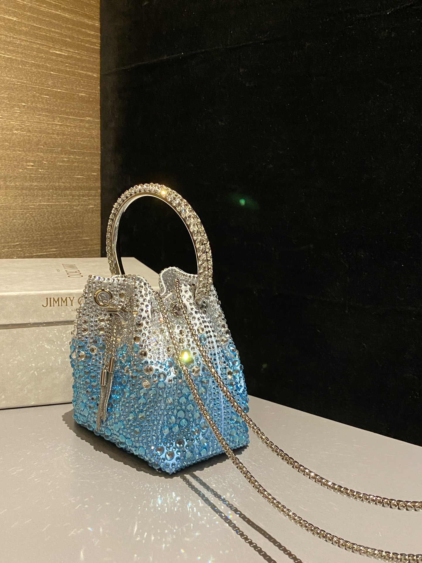 JIMMY CHOO
BON BON系列标志款手提包,光滑缎面铺嵌渐变水晶制作。
设计灵感源于软硬质感及甜美与张扬气质的强烈对比,点睛配以标志性金属流苏,成就如BON BON之名般个性别致又优雅迷人的时尚包袋。现代感桶包廓形,配以手环造型顶部提手,提手饰有百粒经三天精工颗颗细嵌的水晶,精美雅致,招牌奢华包袋当属本款BON BON手提包。
缎面烫钻水晶手嵌水晶饰手环提手Jimmy Choo logo压印金属流苏开合链条肩带内层口袋包袋尺寸:16(长)x15(高)x9.5(宽)厘米肩带长度:55厘米提手长度:9厘米 20259
