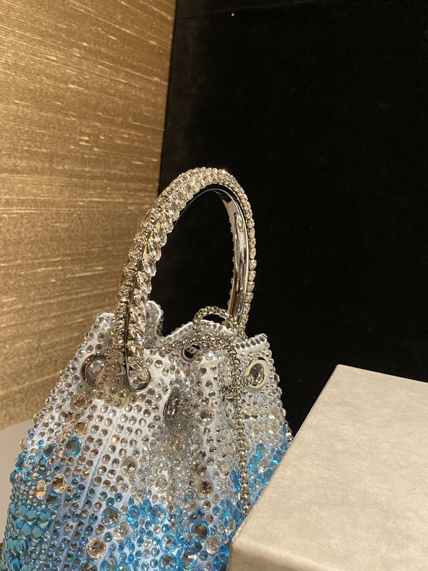 JIMMY CHOO
BON BON系列标志款手提包,光滑缎面铺嵌渐变水晶制作。
设计灵感源于软硬质感及甜美与张扬气质的强烈对比,点睛配以标志性金属流苏,成就如BON BON之名般个性别致又优雅迷人的时尚包袋。现代感桶包廓形,配以手环造型顶部提手,提手饰有百粒经三天精工颗颗细嵌的水晶,精美雅致,招牌奢华包袋当属本款BON BON手提包。
缎面烫钻水晶手嵌水晶饰手环提手Jimmy Choo logo压印金属流苏开合链条肩带内层口袋包袋尺寸:16(长)x15(高)x9.5(宽)厘米肩带长度:55厘米提手长度:9厘米 20259