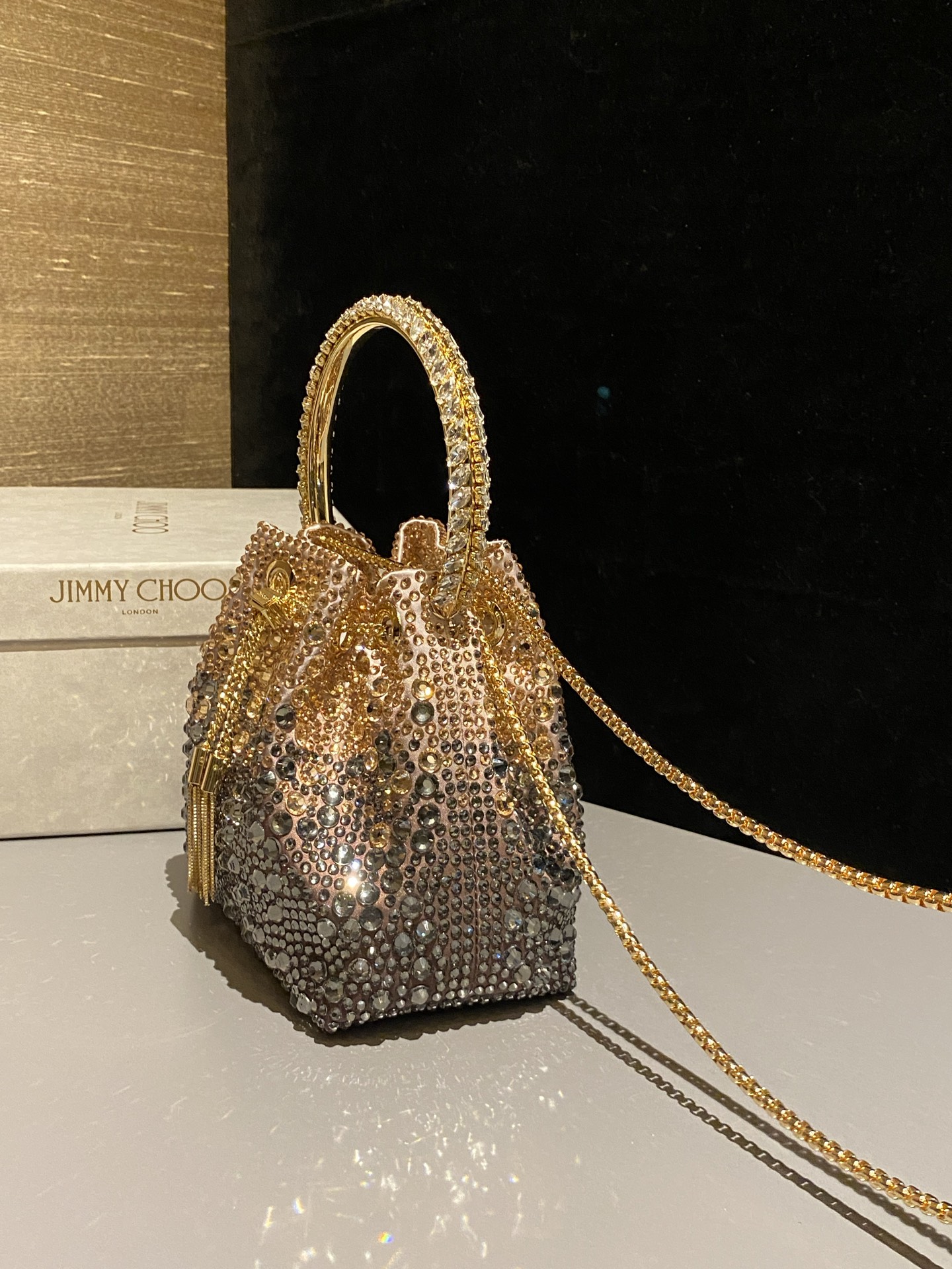 JIMMY CHOO
BON BON系列标志款手提包,光滑缎面铺嵌渐变水晶制作。
设计灵感源于软硬质感及甜美与张扬气质的强烈对比,点睛配以标志性金属流苏,成就如BON BON之名般个性别致又优雅迷人的时尚包袋。现代感桶包廓形,配以手环造型顶部提手,提手饰有百粒经三天精工颗颗细嵌的水晶,精美雅致,招牌奢华包袋当属本款BON BON手提包。
缎面烫钻水晶手嵌水晶饰手环提手Jimmy Choo logo压印金属流苏开合链条肩带内层口袋包袋尺寸:16(长)x15(高)x9.5(宽)厘米肩带长度:55厘米提手长度:9厘米 20259