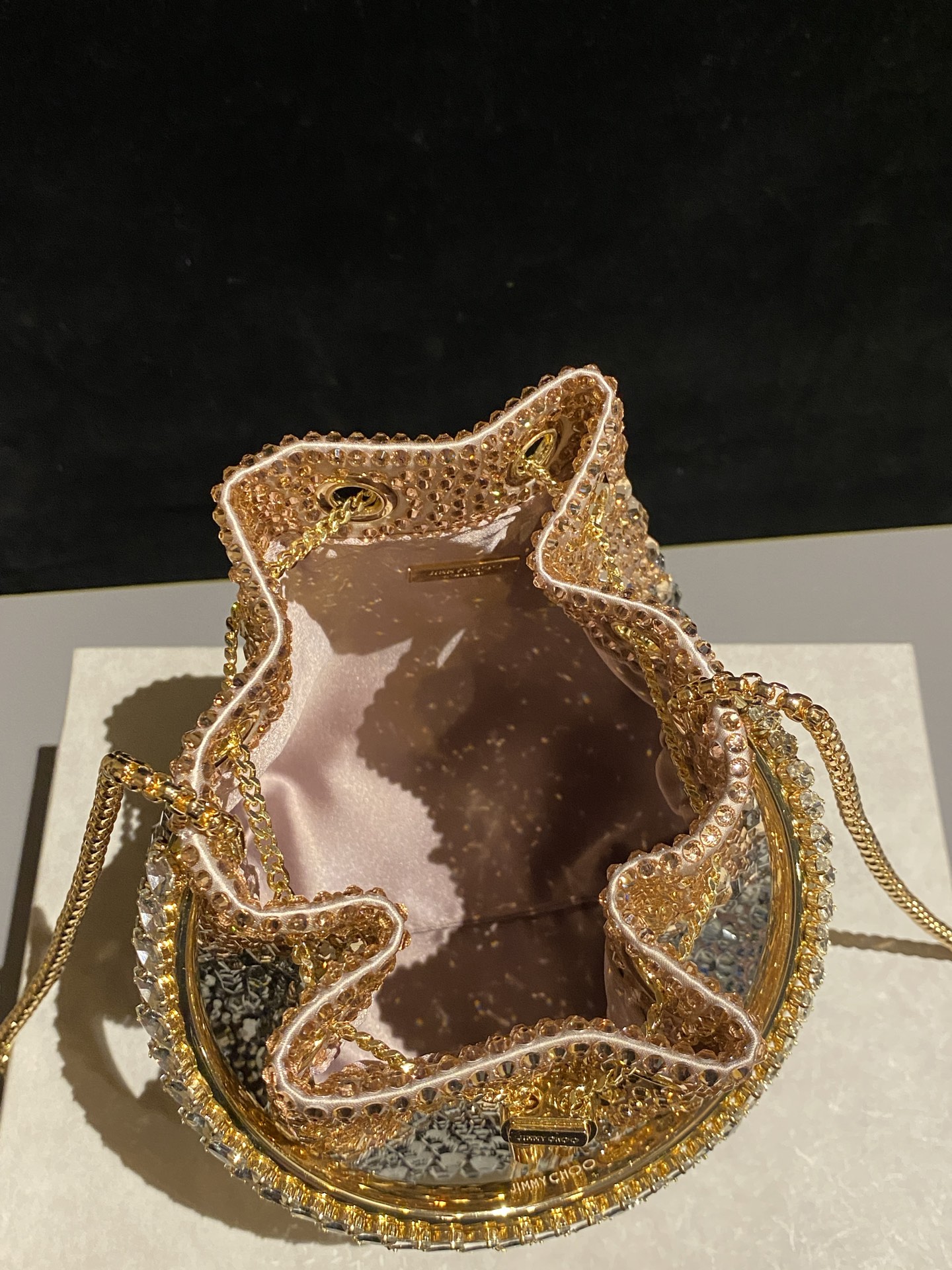 JIMMY CHOO
BON BON系列标志款手提包,光滑缎面铺嵌渐变水晶制作。
设计灵感源于软硬质感及甜美与张扬气质的强烈对比,点睛配以标志性金属流苏,成就如BON BON之名般个性别致又优雅迷人的时尚包袋。现代感桶包廓形,配以手环造型顶部提手,提手饰有百粒经三天精工颗颗细嵌的水晶,精美雅致,招牌奢华包袋当属本款BON BON手提包。
缎面烫钻水晶手嵌水晶饰手环提手Jimmy Choo logo压印金属流苏开合链条肩带内层口袋包袋尺寸:16(长)x15(高)x9.5(宽)厘米肩带长度:55厘米提手长度:9厘米 20259
