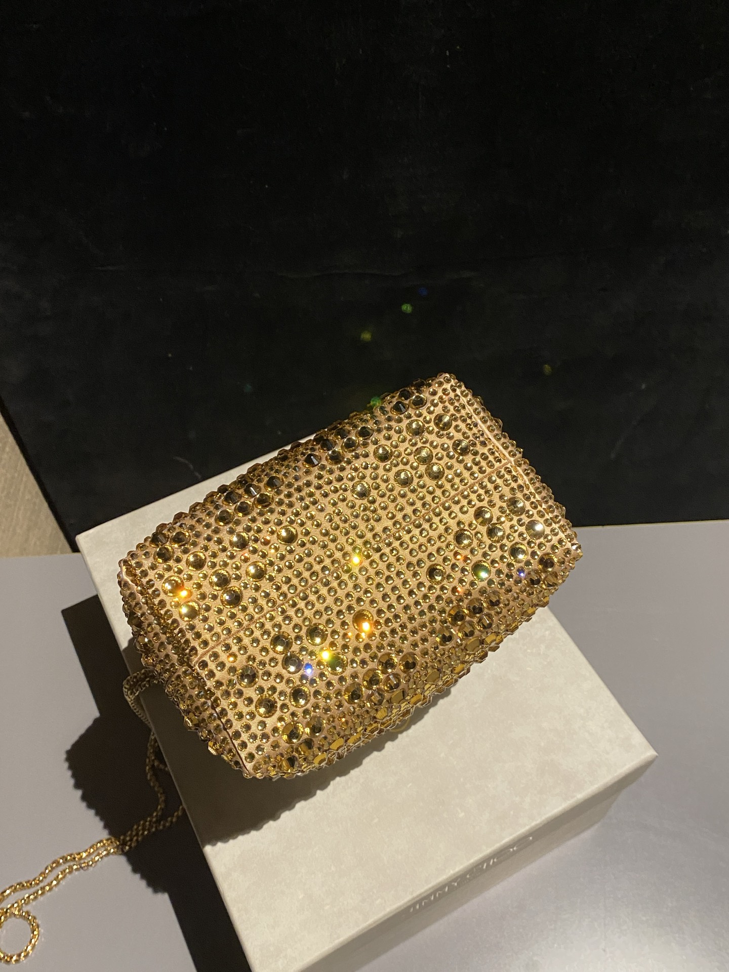 JIMMY CHOO
BON BON系列标志款手提包，光滑缎面铺嵌渐变水晶制作。
设计灵感源于软硬质感及甜美与张扬气质的强烈对比，点睛配以标志性金属流苏，成就如BON BON之名般个性别致又优雅迷人的时尚包袋。现代感桶包廓形，配以手环造型顶部提手，提手饰有百粒经三天精工颗颗细嵌的水晶，精美雅致，招牌奢华包袋当属本款BON BON手提包。
缎面烫钻水晶手嵌水晶饰手环提手Jimmy Choo logo压印金属流苏开合链条肩带内层口袋包袋尺寸：16（长）x15（高）x9.5（宽）厘米肩带长度：55厘米提手长度：9厘米 20259 