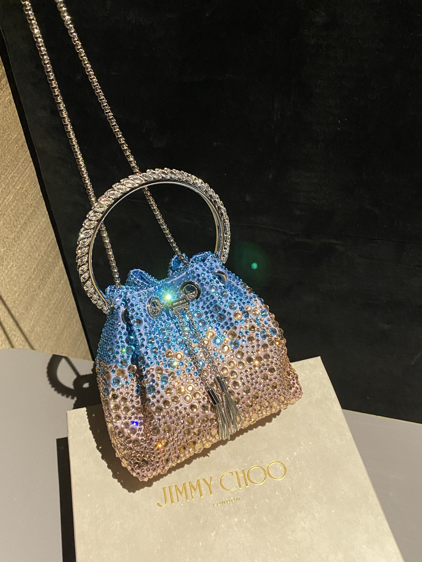 JIMMY CHOO
BON BON系列标志款手提包,光滑缎面铺嵌渐变水晶制作。
设计灵感源于软硬质感及甜美与张扬气质的强烈对比,点睛配以标志性金属流苏,成就如BON BON之名般个性别致又优雅迷人的时尚包袋。现代感桶包廓形,配以手环造型顶部提手,提手饰有百粒经三天精工颗颗细嵌的水晶,精美雅致,招牌奢华包袋当属本款BON BON手提包。
缎面烫钻水晶手嵌水晶饰手环提手Jimmy Choo logo压印金属流苏开合链条肩带内层口袋包袋尺寸:16(长)x15(高)x9.5(宽)厘米肩带长度:55厘米提手长度:9厘米 20259