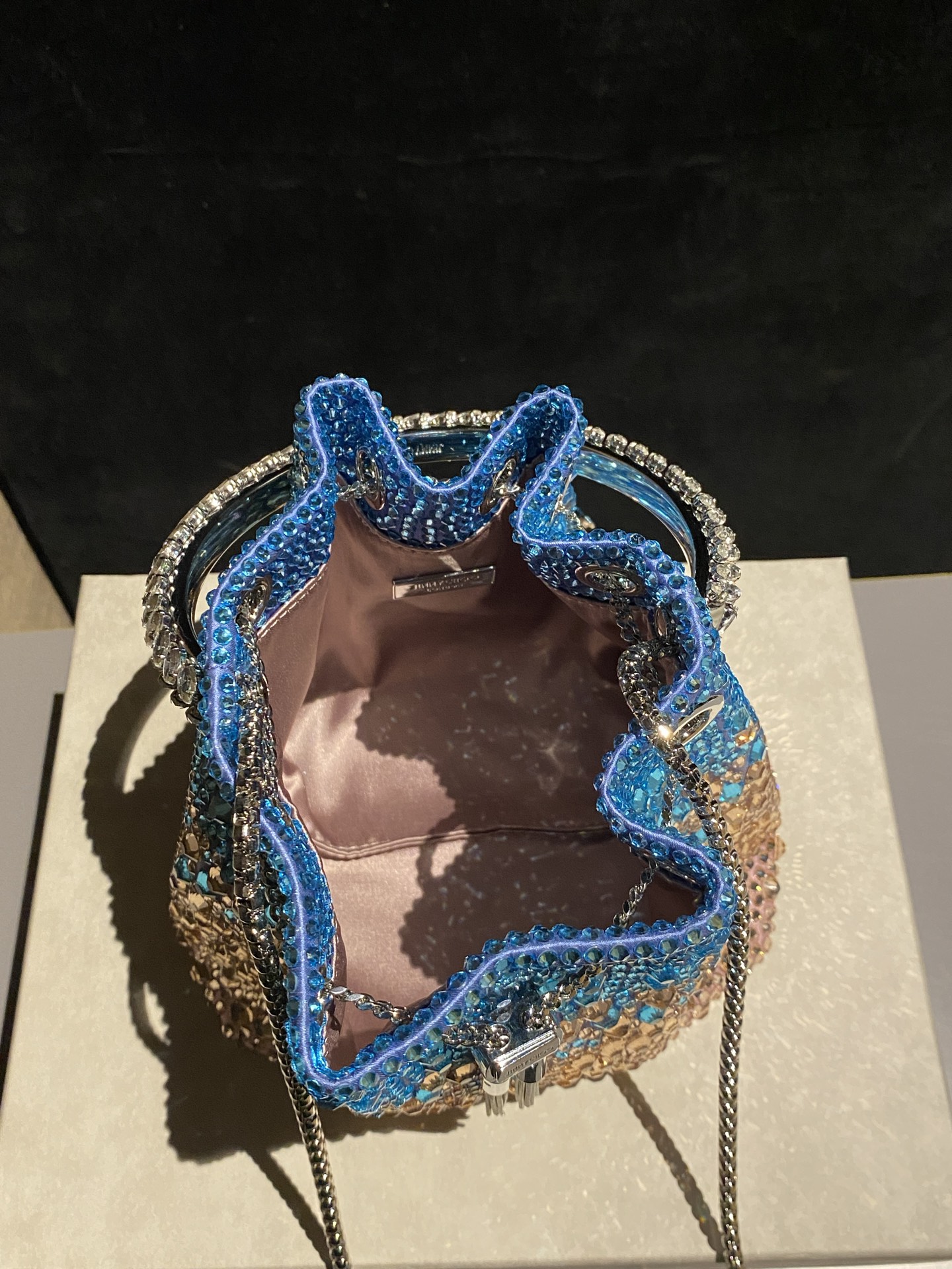 JIMMY CHOO
BON BON系列标志款手提包,光滑缎面铺嵌渐变水晶制作。
设计灵感源于软硬质感及甜美与张扬气质的强烈对比,点睛配以标志性金属流苏,成就如BON BON之名般个性别致又优雅迷人的时尚包袋。现代感桶包廓形,配以手环造型顶部提手,提手饰有百粒经三天精工颗颗细嵌的水晶,精美雅致,招牌奢华包袋当属本款BON BON手提包。
缎面烫钻水晶手嵌水晶饰手环提手Jimmy Choo logo压印金属流苏开合链条肩带内层口袋包袋尺寸:16(长)x15(高)x9.5(宽)厘米肩带长度:55厘米提手长度:9厘米 20259