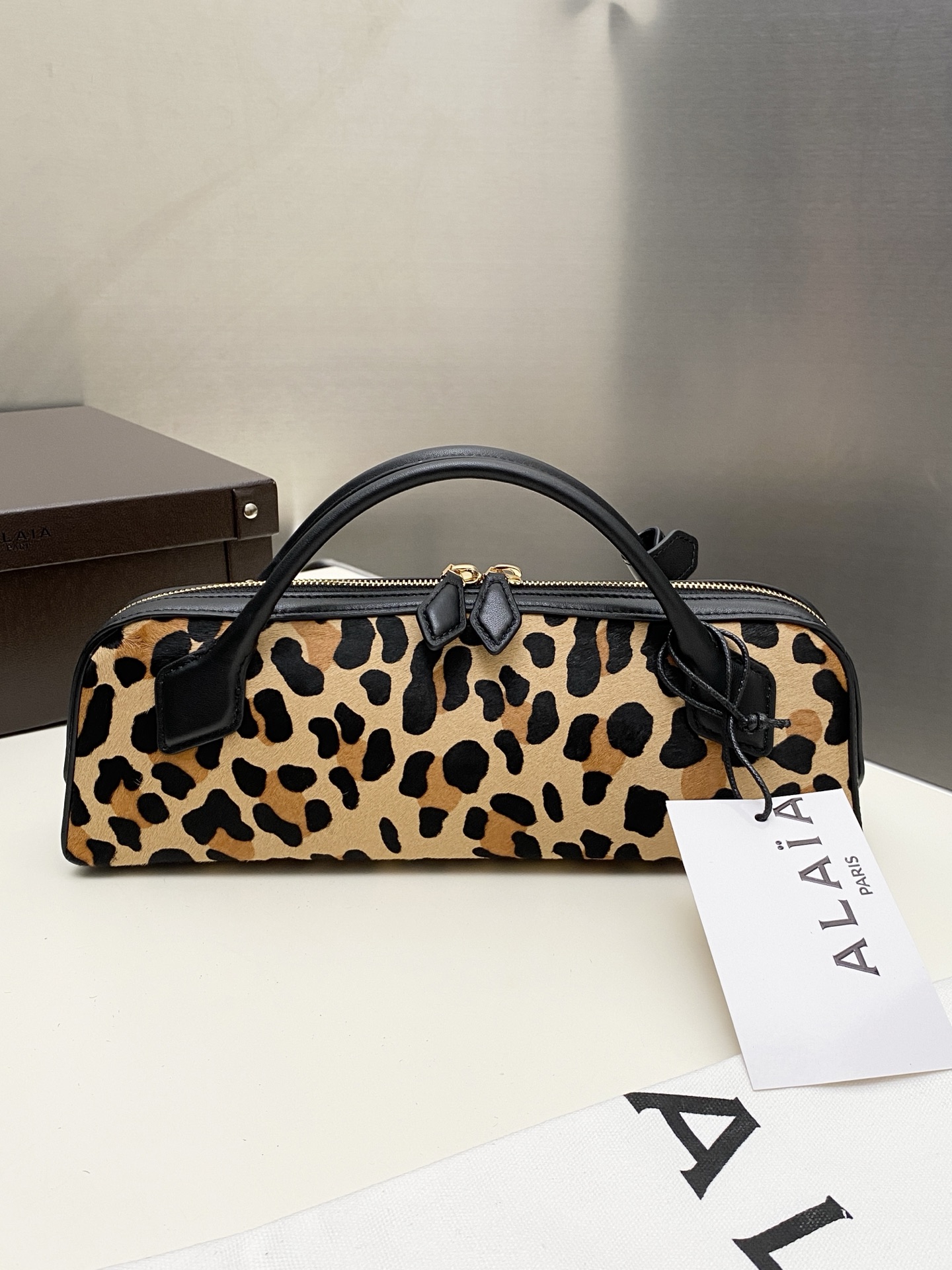 NO:552539,Alaia sausage new product 24101 LE TECKEL leopard print suede leather clutch bag This leopard print clutch adopts the iconic LE TECKEL bag design, with a slender silhouette, short tubular handle, decorated with decorative knots, double zipper closure design, and an internal pocket decorated with a small removable mirror; made of suede cowhide, the leopard print pattern on the calfskin easily highlights the fashionable and modern style. Dimensions (cm) length 31 x width 10 x  High 7 Made in Italy Main material Leather Main lining Leather, DG, alaia, handbag, cowhide19860909Alaia腊肠 新品24101 LE TECKEL豹纹翻毛牛皮手拿包 该款豹纹手拿包,采用标志性LE TECKEL包袋设计,修长廓形,短管状手柄,饰以装饰结,搭配双拉链开合设计,内部口袋缀以小号可拆卸镜面；由翻毛牛皮制成,小牛皮上的豹纹图案,轻松凸显时尚摩登型格. 尺寸（厘米）长31 x 宽10 x 高7 意大利制造 材质主料 皮 主衬里 皮,DG,alaia,handbag,cowhide,Bag