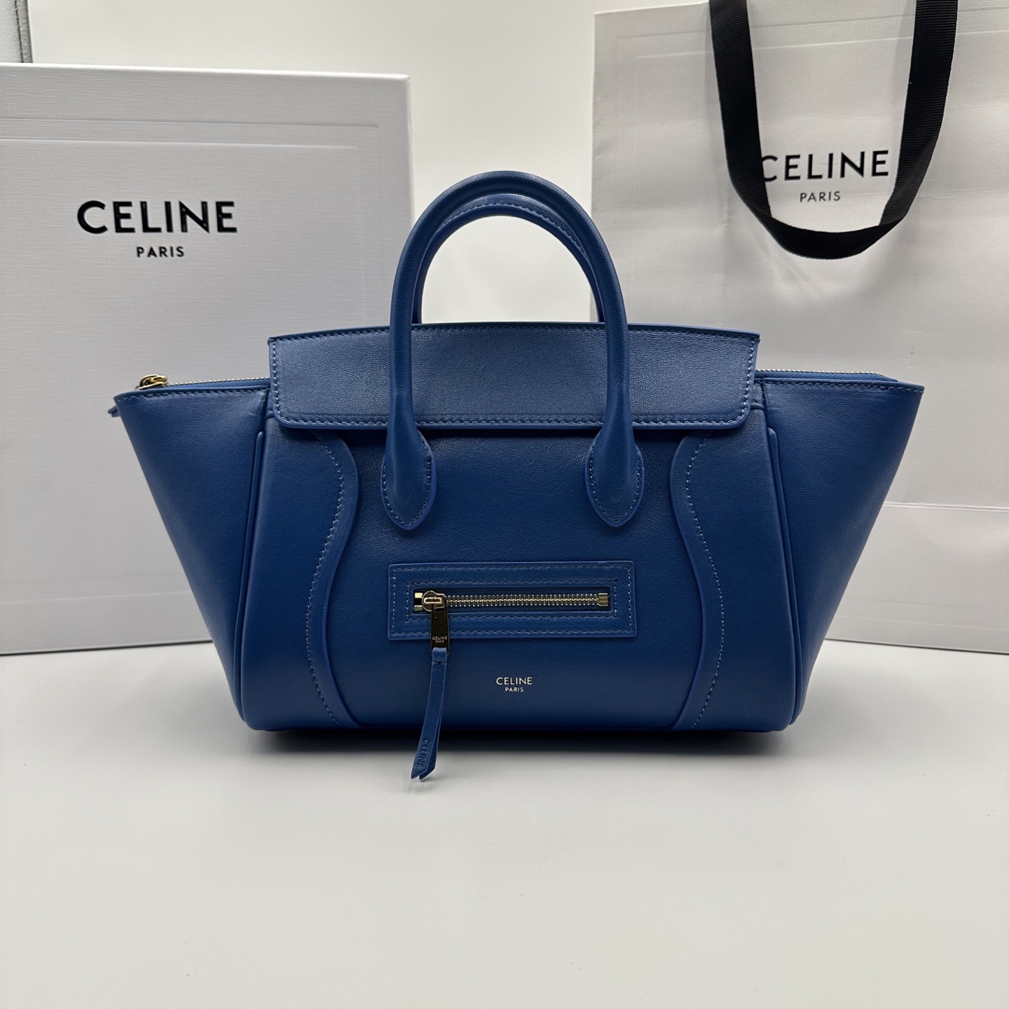 NO:701202,Authentic grade original leather new products online 26 spring series new smiley bag CE smiley bag is back with a new look!  CE PRINTEMPS 2026 Spring Series!  NEW LUGGAGE The classic in memory is reborn!  The light material and modern lines are still the most recognizable It Bag!  It shows a simple and neat modern temperament. The new creative director Michael Rider makes a surprise return. The smooth, delicate and lustrous leather, back seam technology and piping design create a soft and round horizontal profile. The side zipper design presents a unique smile arc, which cleverly echoes this reputation. The classic design is reinterpreted through modern silhouettes, making the whole body more lightweight and versatile, presenting an elegant and casual style!  Style number 124213 Color oxidized blue Size pocket 38.5x11.5x16.5cm (with original packaging), Celine, celine19860909正品级 原厂皮 新品上线 26春季系列全新笑脸包 CE笑脸包焕新回归！ CE PRINTEMPS 2026春季系列！ NEW LUGGAGE 记忆中的经典,焕新登场！ 轻盈的材质,摩登的线条 依旧是那个辨识度拉满的It Bag！ 尽显简约利落的摩登气质.新任创意总监 Michael Rider 惊喜回归,柔滑细腻且富有光泽的皮革,背缝工艺和滚边设计塑造出柔和圆润的横版轮廓,侧面拉链设计呈现独特的微笑弧度,巧妙呼应 这一美名.通过现代廓形重释经典设计,整体更加轻便百搭,呈现优雅又随性的风格！ 款号124213 颜色氧化蓝色 尺寸袋口38.5x11.5x16.5cm（配原版包装）,赛琳,celine,Bag