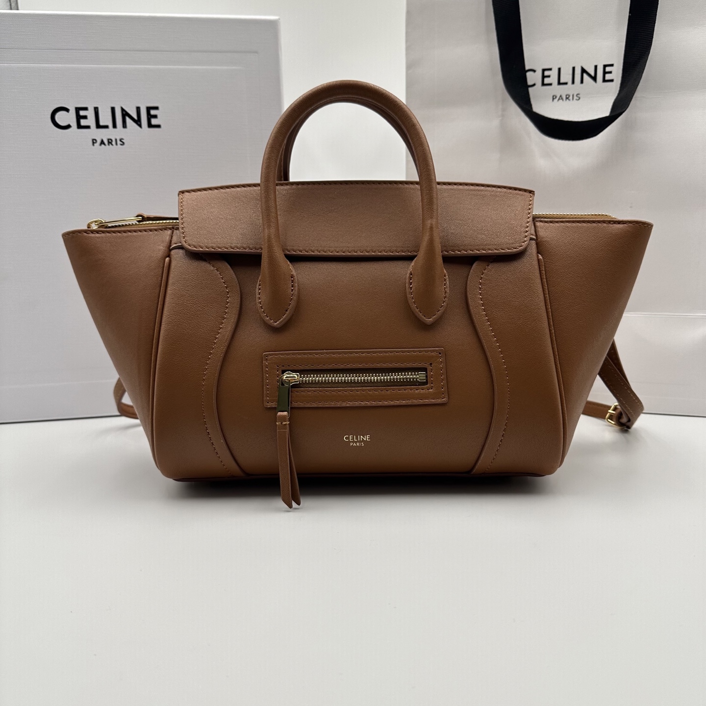 NO:701205,Authentic grade original leather new products online 26 spring series new smiley bag CE smiley bag is back with a new look!  CE PRINTEMPS 2026 Spring Series!  NEW LUGGAGE The classic in memory is reborn!  The light material and modern lines are still the most recognizable It Bag!  It shows a simple and neat modern temperament. The new creative director Michael Rider makes a surprise return. The smooth, delicate and lustrous leather, back seam technology and piping design create a soft and round horizontal profile. The side zipper design presents a unique smile arc, which cleverly echoes this reputation. The classic design is reinterpreted through modern silhouettes, making the whole body more lightweight and versatile, presenting an elegant and casual style!  Style number 124213, color light tan, size pocket 38.5x11.5x16.5cm (with original packaging), Celine, celine19860909正品级 原厂皮 新品上线 26春季系列全新笑脸包 CE笑脸包焕新回归！ CE PRINTEMPS 2026春季系列！ NEW LUGGAGE 记忆中的经典,焕新登场！ 轻盈的材质,摩登的线条 依旧是那个辨识度拉满的It Bag！ 尽显简约利落的摩登气质.新任创意总监 Michael Rider 惊喜回归,柔滑细腻且富有光泽的皮革,背缝工艺和滚边设计塑造出柔和圆润的横版轮廓,侧面拉链设计呈现独特的微笑弧度,巧妙呼应 这一美名.通过现代廓形重释经典设计,整体更加轻便百搭,呈现优雅又随性的风格！ 款号124213 颜色浅棕褐色 尺寸袋口38.5x11.5x16.5cm（配原版包装）,赛琳,celine,Bag