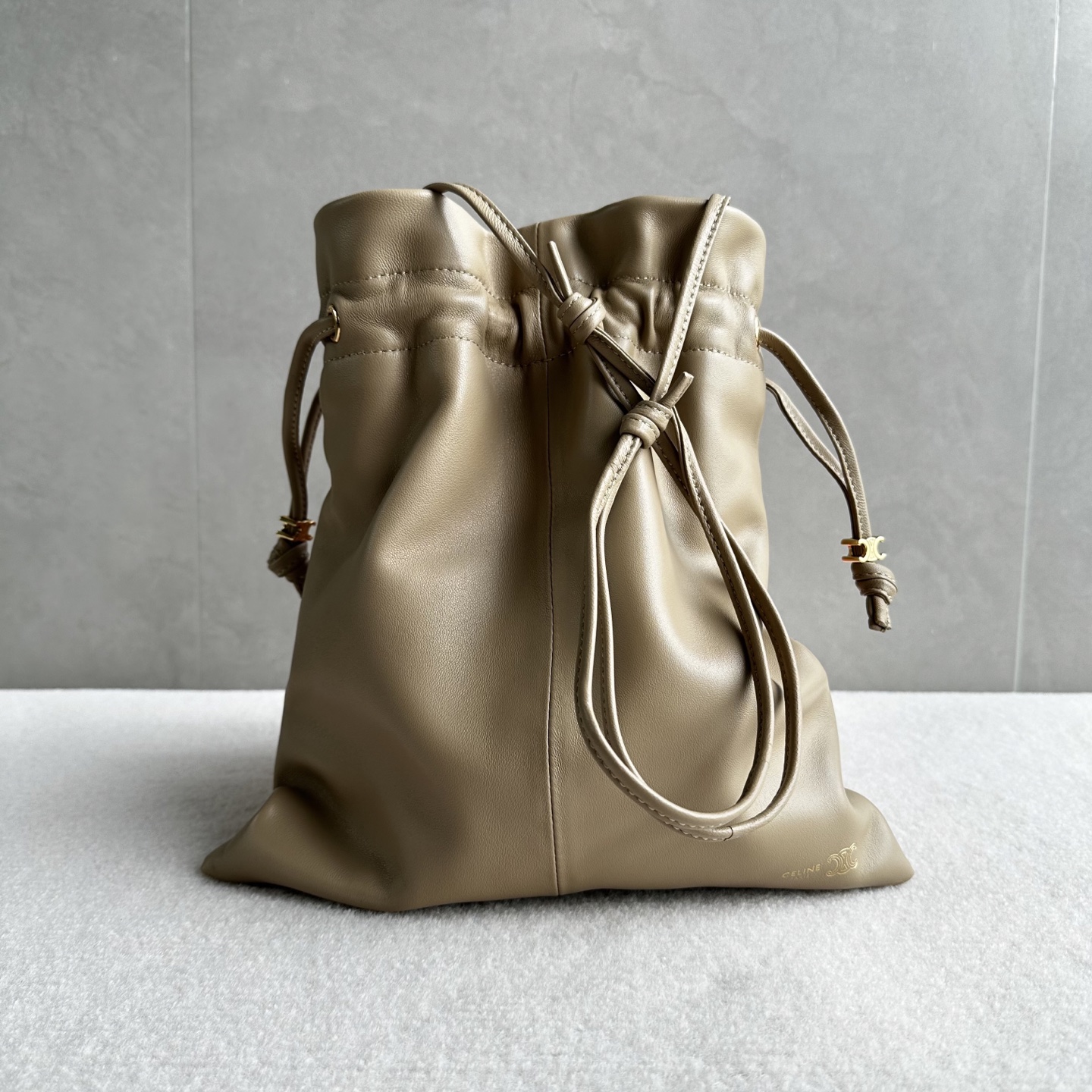 NO:852215,Genuine grade original leather, new products launched, CE lucky bag style!  The drawstring design gives a cloud-wrapped feel. When loosened, a casual drape line appears. One bag can switch between two visual atmospheres. The embossed Arc de Triomphe logo on the bag body + the hardware drawstring buckle make the brand logo low-key, retaining recognition without appearing to be deliberately public. The Arc de Triomphe dark pattern on the lining hides the details that can be seen after unzipping the drawstring, making the texture unified from the inside to the outside. The bag body is made of soft wrinkled lambskin.  The touch is soft and fufu like clouds. The pleated texture comes with effortless spontaneity. Style number 123662. Color hunting color. Size 29x32×0.5 (with original packaging), Celine, celine, sheepskin.19860909正品级 原厂皮 新品上线 CE 福袋包款！ 抽绳的设计,云朵包裹感 松开则是随性的垂坠线条 一包能切换两种视觉氛围 包身的压印凯旋门logo+五金抽绳扣,把品牌标识做了低调化处理 ,既保留辨识度,又不会显得刻意张扬 内衬的凯旋门暗纹是 隐藏精致项拉开抽绳就能看到的细节 ,让质感从内到外统一 包身采用软皱小羊皮 触感是软fufu的云朵感 褶皱肌理自带 不费力的随性 款号123662 颜色猎装色 尺寸29x32×0.5（配原版包装）,赛琳,celine,sheepskin,Bag