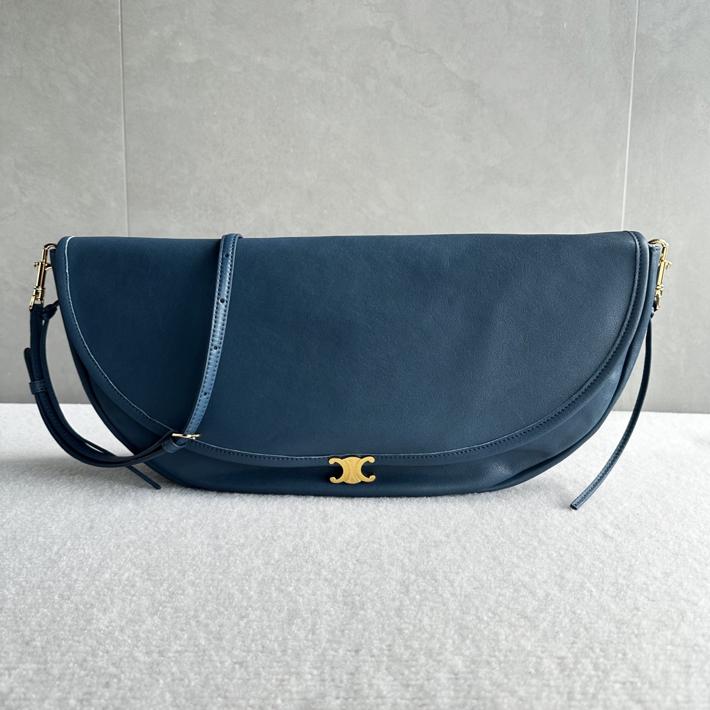 NO:852189,The new series of authentic CE Halfmoon bags are based on soft and shiny sheep leather, combining rounded lines and three-dimensional tailoring, emphasizing the dual consideration of function and shape. The iconic Triomphe magnetic buckle has been miniaturized and integrated into the bag body in a more restrained form. The two bag types - the clamshell Besace and the curved Half Moon, can be carried on the shoulder or cross-body, taking into account the needs of daily and urban multiple scenes, building an everyday French style silhouette between lightness and practicality. -  Soft Triomphe's meticulous treatment of materials, craftsmanship and proportions embodies CELINE's aesthetic philosophy of building strength in silence. From low-key colors to exquisite metal details, it is not only a modern interpretation of the brand's classics, but also Michael Rider's new writing of contemporary women's bag language. Style No. 124142 Color blue Size 46x19x10cm (with original packaging), Celine, celine, celine, sheepskin19860909正品级  CE Halfmoon 半月包 新系列以柔软亮泽的羊皮革为基调,结合圆润线条与立体剪裁,强调功能与造型的双重兼顾.标志性Triomphe磁吸式扣饰经过微缩设计,以更加内敛的形式融入包体.两种包型——翻盖Besace与弧形Half Moon,皆可肩背或斜挎,兼顾日常与都市多场景需求,在轻盈与实用之间构建日常的法式风格轮廓. - Soft Triomphe在材质、工艺与比例上的精细处理,体现了CELINE在静谧中构建力量的审美哲学.从低调色系到精致金属细节,它不仅是对品牌经典的现代诠释,也是Michael Rider对当代女性包袋语言的全新书写 款号124142 颜色蓝色 尺寸46x19x10cm（配原版包装）,赛琳,celine,celine,sheepskin,Bag
