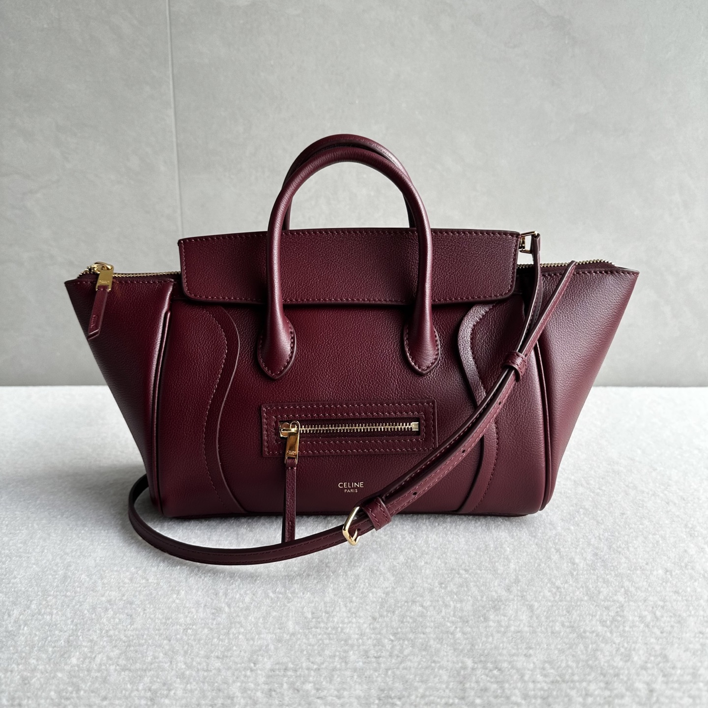 NO:852335,Authentic grade new products online 26 spring series new smiley bag CE smiley bag is back with a new look!  CE PRINTEMPS 2026 Spring Series!  NEW LUGGAGE The classic in memory is reborn!  The light material and modern lines are still the most recognizable It Bag!  It shows a simple and neat modern temperament. The new creative director Michael Rider makes a surprise return. The smooth, delicate and lustrous leather, back seam technology and piping design create a soft and round horizontal profile. The side zipper design presents a unique smile arc, which cleverly echoes this reputation. The classic design is reinterpreted through modern silhouettes, making the whole body more lightweight and versatile, presenting an elegant and casual style!  Style No. 108J3 Color Syrah Grape Red Size Bag Mouth 36x11x16.5cm (with original packaging), Celine, celine19860909正品级 新品上线 26春季系列全新笑脸包 CE笑脸包焕新回归！ CE PRINTEMPS 2026春季系列！ NEW LUGGAGE 记忆中的经典,焕新登场！ 轻盈的材质,摩登的线条 依旧是那个辨识度拉满的It Bag！ 尽显简约利落的摩登气质.新任创意总监 Michael Rider 惊喜回归,柔滑细腻且富有光泽的皮革,背缝工艺和滚边设计塑造出柔和圆润的横版轮廓,侧面拉链设计呈现独特的微笑弧度,巧妙呼应 这一美名.通过现代廓形重释经典设计,整体更加轻便百搭,呈现优雅又随性的风格！ 款号108J3 颜色西拉葡萄红 尺寸袋口36x11x16.5cm（配原版包装）,赛琳,celine,Bag