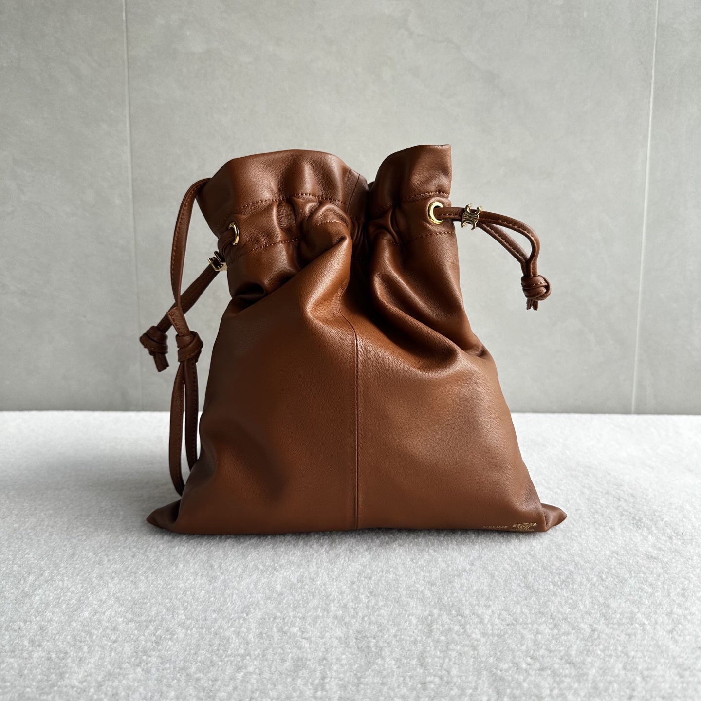 NO:852202,Genuine grade original leather, new products launched, CE lucky bag style!  The drawstring design gives a cloud-wrapped feel. When loosened, a casual drape line appears. One bag can switch between two visual atmospheres. The embossed Arc de Triomphe logo on the bag body + the hardware drawstring buckle make the brand logo low-key, retaining recognition without appearing to be deliberately public. The Arc de Triomphe dark pattern on the lining hides the details that can be seen after unzipping the drawstring, making the texture unified from the inside to the outside. The bag body is made of soft wrinkled lambskin.  The touch is soft and fufu like clouds. The pleated texture comes with ease. Style number 123662. Color brown. Size 29x32×0.5 (with original packaging), Celine, celine, sheepskin.19860909正品级 原厂皮 新品上线 CE 福袋包款！ 抽绳的设计,云朵包裹感 松开则是随性的垂坠线条 一包能切换两种视觉氛围 包身的压印凯旋门logo+五金抽绳扣,把品牌标识做了低调化处理 ,既保留辨识度,又不会显得刻意张扬 内衬的凯旋门暗纹是 隐藏精致项拉开抽绳就能看到的细节 ,让质感从内到外统一 包身采用软皱小羊皮 触感是软fufu的云朵感 褶皱肌理自带 不费力的随性 款号123662 颜色棕色 尺寸29x32×0.5（配原版包装）,赛琳,celine,sheepskin,Bag