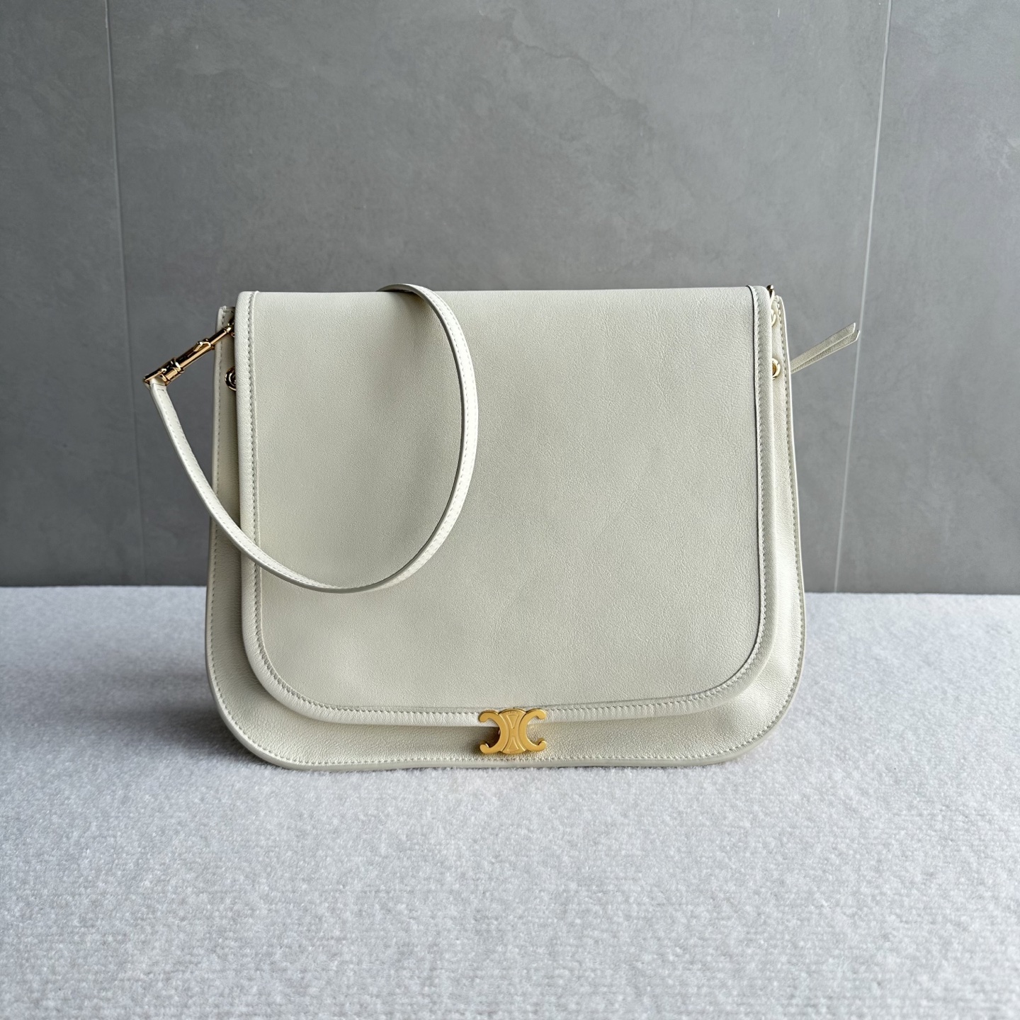 NO:880043,Authentic grade original leather Besace handbags. The latest Soft Triomphe Besace. The recently popular Soft Triomphe Besace is a new style for the spring and summer of 2026, focusing on a 'lazy and fashionable' feeling. ·The bag design is more square than the classic half-moon bag. The box-shaped structure makes it look more stiff and has a larger capacity. It can easily hold a folding umbrella, a thermos cup and a cosmetic bag.  ·The material and feel are made of soft natural grained shiny lambskin, which has a delicate feel and is very light in weight, so it is not burdensome to carry. ·Practical details There is a zipper pocket on the back of the bag, which can be used to store mobile phones or keys, which is very convenient. The magnetic buckle is low-key. The Triomphe emblem has a crisp 'click' sound when opening and closing.  . It is equipped with a detachable and adjustable shoulder strap that can be carried in various ways. It can be carried on one shoulder, cross-body or hand-held. It has a French lady feel when paired with a suit jacket. Style number 123632 Color cotton white Size 32x2x26cm (with original packaging), Celine, celine, cosmetic bags & cases, jackets & coats, business suit, sheepskin19860909正品级 原厂皮 Besace 手袋 最新款 Soft Triomphe Besace 最近很火的 Soft Triomphe Besace 是2026春夏的新款,主打一个“慵懒时髦”的感觉. ·包型设计相比经典的半月包,这款 Besace 更加方正一些,箱型结构让它看起来更挺括,容量也更大,能轻松装下折叠伞、保温杯和化妆包. ·材质与手感采用柔软的天然粒面亮泽小羊皮,手感细腻,自重很轻,背起来没有负担. ·实用细节包身背面有一个拉链口袋,可以放手机或钥匙,非常方便.磁吸扣是低调的. Triomphe 徽记,开合时有清脆的“咔哒”声. .背法多样配有可拆卸和可调节的肩带,可以单肩、斜挎,也可以手提,搭配西装外套很有法式小姐姐的感觉. 款号123632 颜色棉花白 尺寸32x2x26cm（配原版包装）,赛琳,celine,cosmetic bags & cases,jackets & coats,business suit,sheepskin,Bag