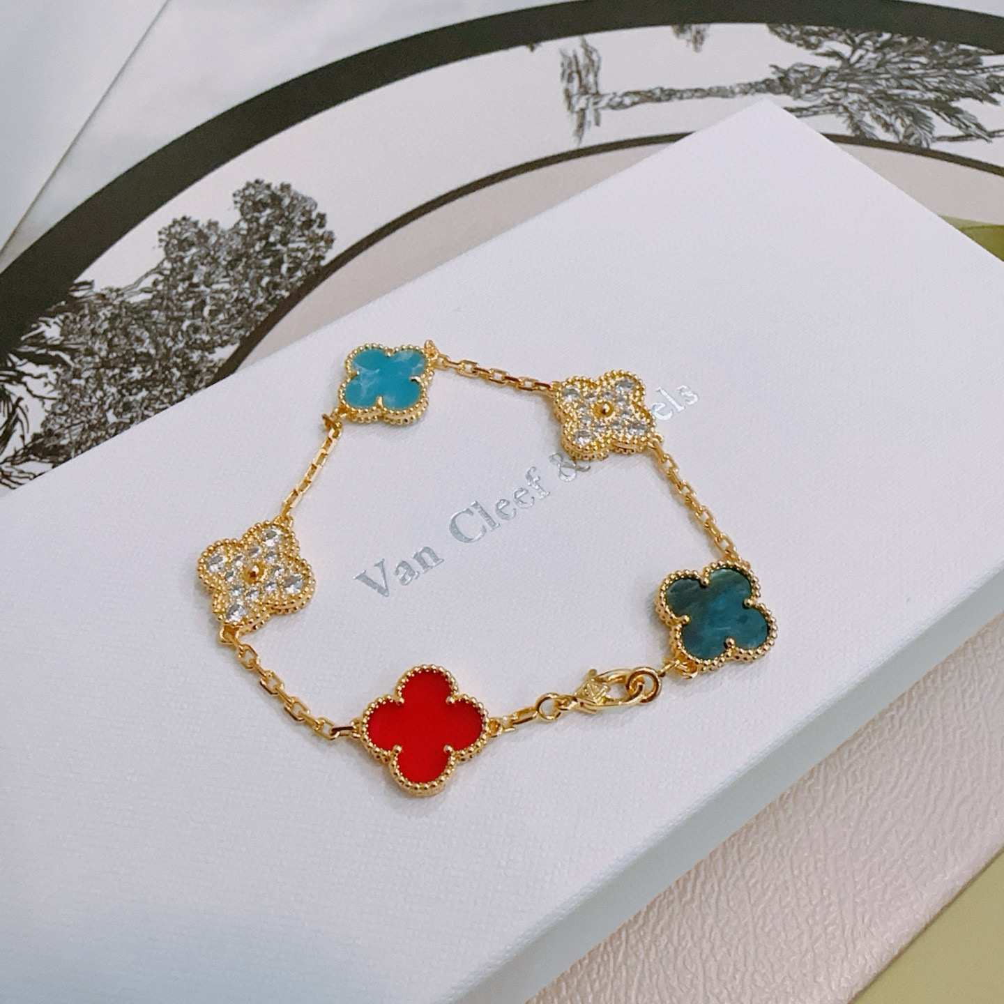 Van Cleef Arpels Pulsera Alhambra Metal dorado con motivos de trébol de cuatro hojas rojo turquesa azul verde azulado y detalles de diamantes transparentes 17 cm