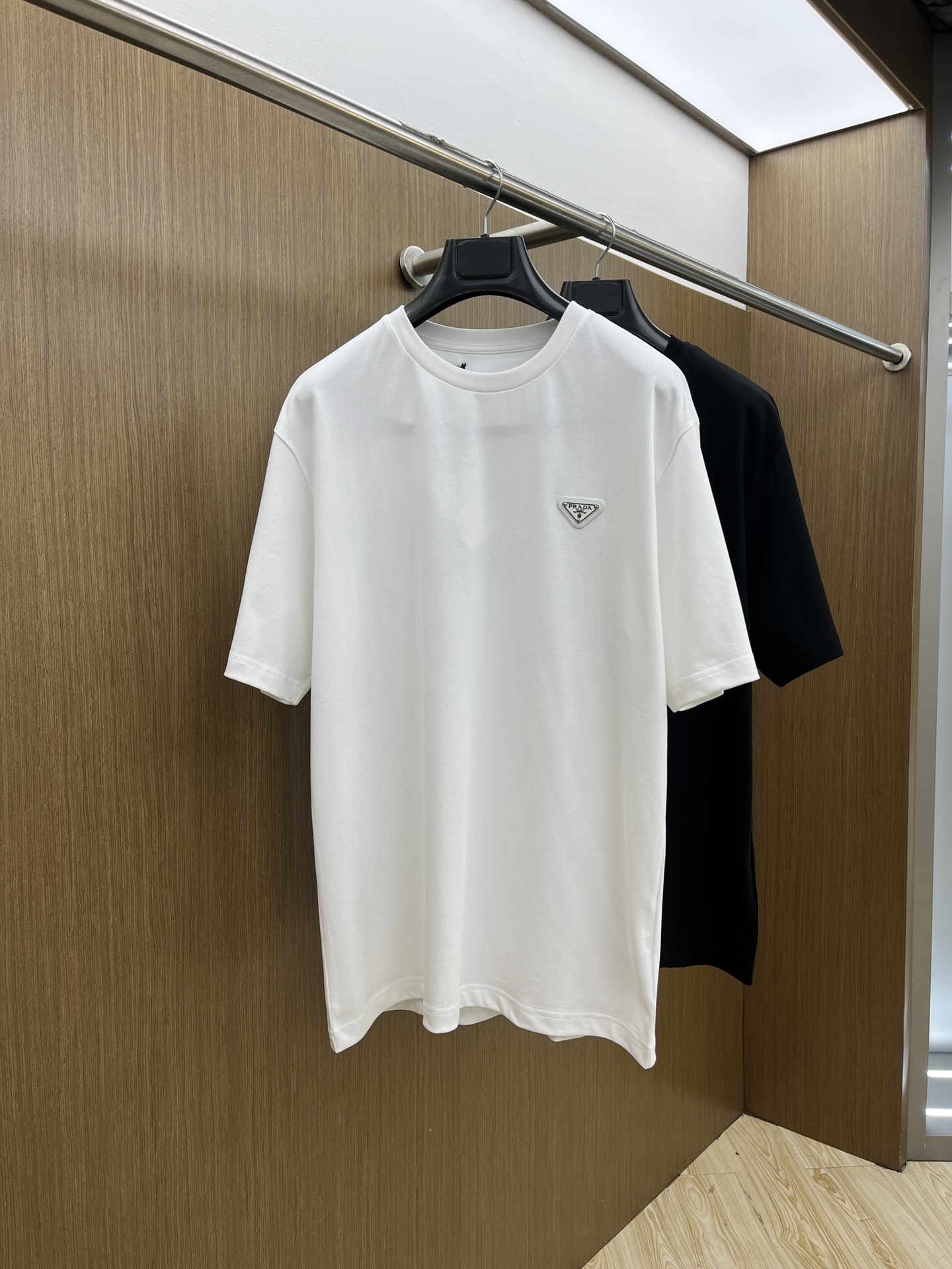 NO:143923,PRADA/Prada 2025 new classic chest triangle logo short-sleeved T-shirt. A simple and luxurious encounter - Prada classic T-shirt. A classic Prada T-shirt is a classic in the wardrobe that never goes out of date. Pure black fabric, low-key and calm, with high texture, and every inch tells the Italian craftsmanship. The iconic triangle logo on the chest is like a silent fashion statement, which low-key highlights the brand's heritage and style. When wearing it, whether it is walking on the street with jeans or wearing a suit for semi-formal occasions, you can easily control it, revealing luxurious taste in simplicity, making daily outfits have extraordinary style. GZ Color Black White Size S-XXL,,prada,prada,jeans,T-shirt,tees,t-shirt,business suit,alexander wang19860909PRADA/普拉达2025新款经典胸前三角标logo短袖T恤衫 简约与奢华的邂逅——Prada经典T恤 一件Prada经典T恤,是衣橱里永不过时的经典.纯黑面料,低调沉稳,质感上乘,每一寸都诉说着意式匠心.胸口标志性三角徽标,似无声的时尚宣言,低调彰显品牌底蕴与格调. 穿上它,无论是搭配牛仔裤漫步街头,还是外搭西装出席半正式场合,都能轻松驾驭,于简约中流露奢华品味,让日常着装也拥有非凡格调. GZ 颜色黑色 白色 尺码S-XXL,,prada,prada,jeans,T-shirt,tees，t-shirt,business suit,alexander wang,Men's clothing