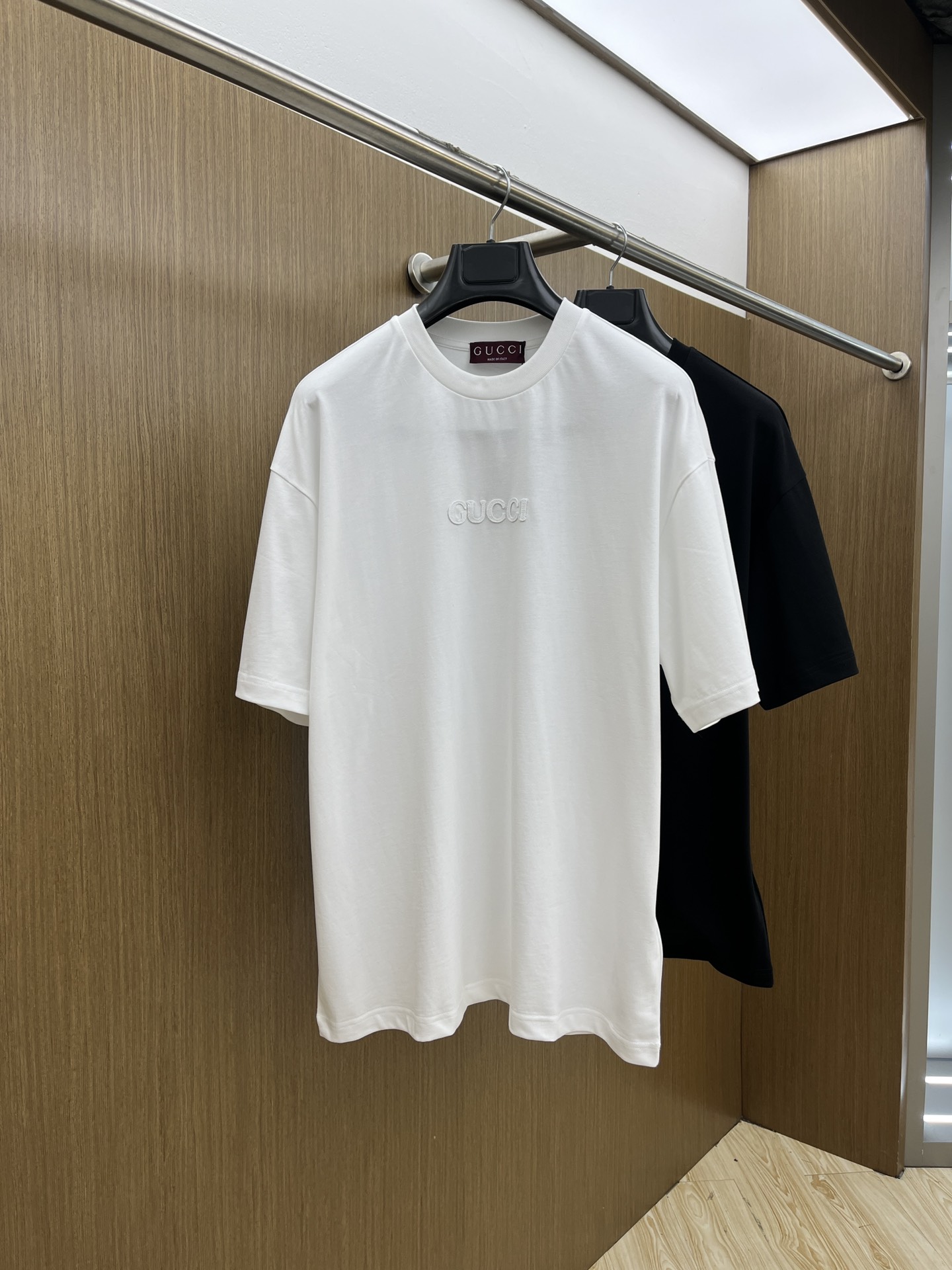 NO:143932,GUCCI/Gucci 2025 new three-dimensional embroidered short-sleeved T-shirts are the same as men and women. The encounter between classic and fashion. When simple brushstrokes meet the luxury genes, this T-shirt came into being. Low-key hidden sharpness is a classic background color that never goes out of date in the fashion industry. The exquisite GUCCI logo on the chest is carved with delicate craftsmanship, like the finishing touch, quietly telling the craftsmanship and style of the brand's century-old inheritance. The loose style outlines casual posture, does not stick to the body constraints, and freely interprets casual style. Whether it is matched with retro denim, walking on the street to show an unruly attitude; or a neat suit on the outside, showing modern taste in the city, it can be easily controlled.  Wearing it is not simply a piece of clothing, but wearing the luxurious soul of GUCCI on its body, showing its unique charm and high-end fashion in every move. GZ Color Black White Size S-XXL,,gucci,gucci,T-shirt,tees,t-shirt,business suit,alexander wang19860909GUCCI/古驰2025新款立体贴布刺绣短袖t恤男女同款 经典与时尚的邂逅,当简约笔触邂逅奢华基因,GUCCI这款T恤应运而生.低调中暗藏锋芒,是时尚界永不过时的经典底色.胸前精致的GUCCI标识,以细腻工艺雕琢,宛如点睛之笔,悄然诉说着品牌百年传承的匠心与格调. 宽松版型,勾勒随性姿态,不拘泥于身形束缚,自在演绎休闲风尚.无论是搭配复古牛仔,漫步街头彰显不羁态度；还是外搭利落西装,出入都市彰显摩登品味,它都能轻松驾驭. 穿上它,不是简单披上一件衣物,而是将GUCCI的奢华灵魂披挂上身,于举手投足间,尽显独特魅力与高阶时尚. GZ 颜色黑色 白色 尺码S-XXL,,gucci,gucci,T-shirt,tees，t-shirt,business suit,alexander wang,Men's clothing