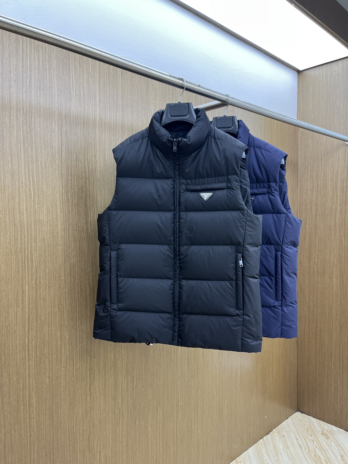 NO:514006,Autumn and Winter PD 25 Autumn and Winter down vest Classic stand-up collar design, low-key black and gray tone exudes a restrained and high-end texture. Paired with the iconic triangle logo, the brand identity is highlighted in the details, whether it is simple or casual, it can instantly enhance the overall style. Continue the brand's precise control of tailoring, adopt a three-dimensional slim fit style, the stand-up collar lines are neat and crisp, outline the neck contour, and say goodbye to the bloated and dragged. Whether it is daily layering or single wear highlighting levels, it can naturally fit the body, adapt to diverse style scenes, taking into account neatness and comfort, and easily grasp the slack and high-end feeling. The triangle logo on the chest is fully recognizable, as the brand DNA  The existence of style is low-key to show identity; the sleeveless design focuses on neatness, streamlined but not loses details, the quilting process is regular and delicate, which not only fixes down but also enhances the visual three-dimensional sense. FJJ minimalist hidden the ultimate pursuit of quality, and every stitch interprets the luxurious aesthetic of Prada style. Number of codes 48 50 52 54 56,,prada,down jacket,alexander wang19860909秋冬 PD 25秋冬款羽绒马甲 经典的立领设计,低调的黑灰调,散发着内敛而高级的质感,搭配标志性的三角徽标,于细微处彰显品牌身份,无论是搭配简约还是休闲,都能瞬间提升整体造型的格调. 延续品牌对剪裁的精准把控,采用立体修身版型,立领线条利落挺括,勾勒颈部轮廓,告别臃肿拖沓.无论日常叠穿、,还是单穿凸显层次,都能自然贴合身形,适配多元风格场景,兼顾利落与舒适,轻松拿捏松弛高级感.  胸前三角徽标辨识度拉满,作为品牌 DNA 式的存在,低调彰显身份；无袖设计聚焦利落感,精简却不失细节,绗缝工艺规整细腻,既固定羽绒不跑绒,又强化视觉立体感,fjj极简中藏着对品质的极致追求,每一处针脚都诠释 Prada 式的奢华美学. 码数48 50 52 54 56,,prada,down jacket,alexander wang,Men's clothing