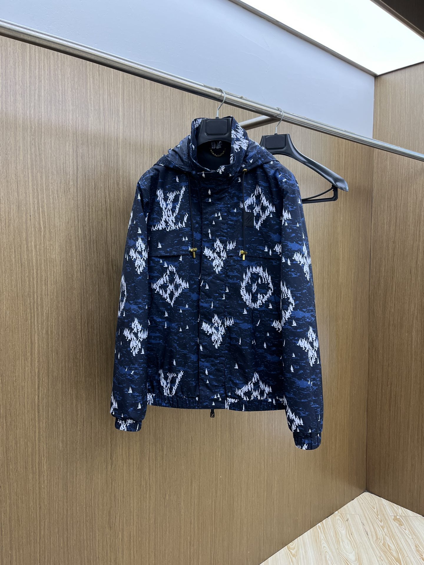 NO:515044,Autumn and winter LV dark blue sailboat printed nylon hooded with dark blue as the background color, covered with white sailboat printed patterns, which combines fashion and uniqueness. The hooded design is casual and has certain wind and rainproof functions, and is suitable for wearing in various occasions. It is equipped with drawstrings, and the metal pendant at both ends of drawstrings is engraved with the words 'LOUIS VUITTON' to increase brand recognition. There is a black rubber sign on the left chest, with brand letter information imprinted on it, which is low-key and highlights the brand identity. The opening and closing place uses a combination of zippers and snaps to increase the firmness of the closure. The zipper head is designed with a simple design, and the snaps also has brand-related marks. There is a larger pocket on the front, which is convenient for placing small items with carry-ons. The cuffs and hem are elastic, which can effectively block the cold wind from entering, making it comfortable and fit the body.  The inner part is black, the material is smooth, and the skin feels comfortable when worn. In some parts of the inner part, there is also a golden chain decoration. This main material is made of nylon, which is wear-resistant and windproof. FSH is not easy to pill or damage when worn on a daily basis. When it comes to light wind, it can also play a certain barrier role to keep the body dry. Number of 48-56,,louis vuitton,louis vuitton,hats,alexander wang19860909秋冬 LV深蓝色帆船印花尼龙连帽 以深蓝色为底色,布满白色帆船印花图案,兼具时尚感与独特性. 连帽设计,休闲且具有一定的防风防雨功能,适合多种场合穿着. 配有抽绳,抽绳两端的金属坠饰上刻有“LOUIS VUITTON”字样,增添品牌辨识度. 左胸前位置设有一块黑色橡胶标识牌,上面压印着品牌字母信息,低调又彰显品牌身份. 开合处采用拉链与按扣结合的方式,增加闭合的牢固性,拉链头设计简洁 ,按扣上也有品牌相关印记. 正面设有较大的口袋,方便放置随身小物品. 袖口和下摆处采用松紧设计,能有效阻挡寒风进入,穿着舒适且贴合身形. 内里为黑色,材质顺滑,穿着时皮肤触感舒适.在内里部分位置,还设有金色链条装饰 这款主料采用锦纶,耐磨又防风,fsh日常穿不容易起球、破损,遇到小风天气,也能起到一定阻隔作用,保持身体干爽. 码数48-56,,louis vuitton,louis vuitton,hats,alexander wang,Men's clothing