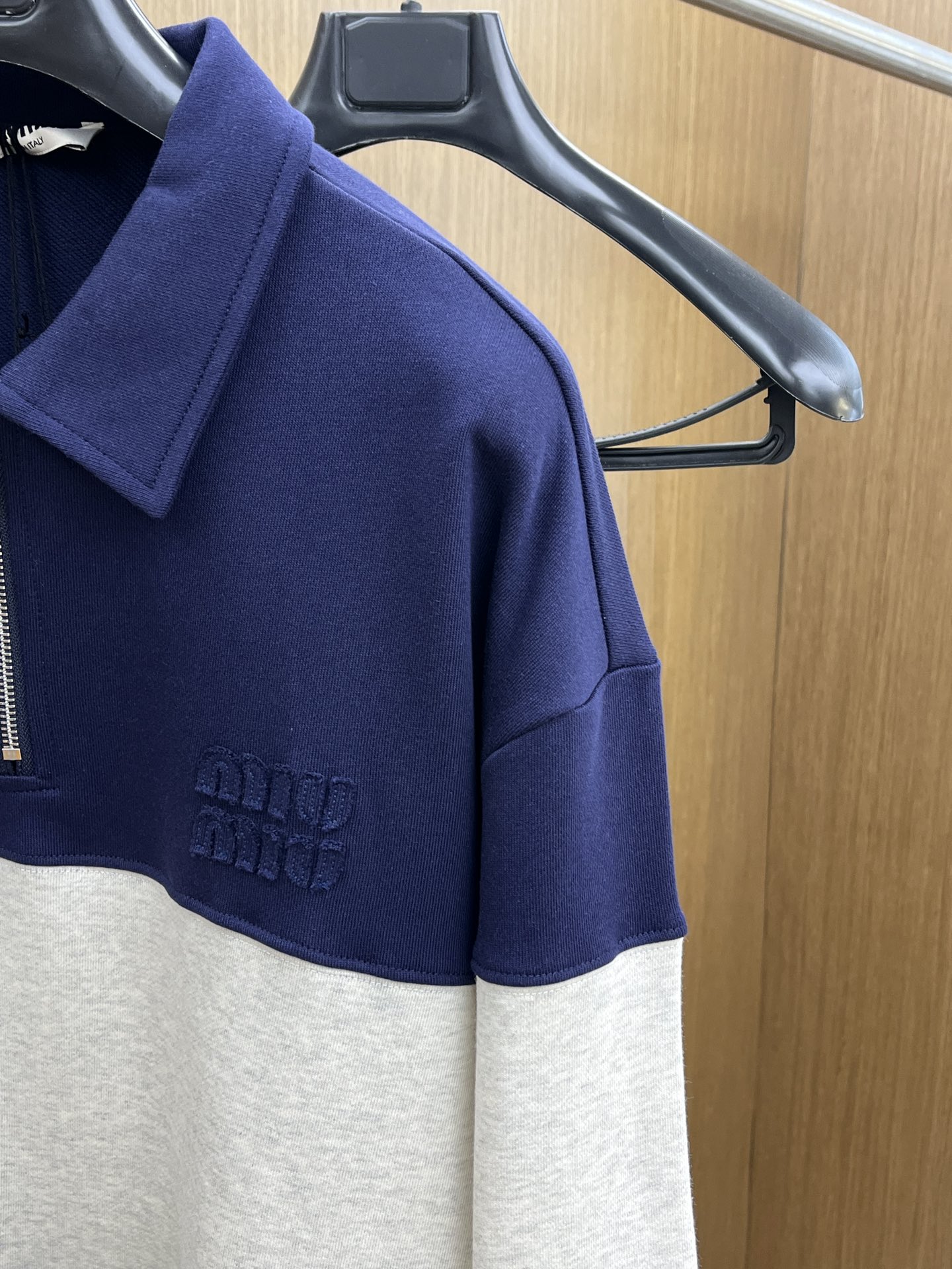 MiuMiu缪缪2025秋冬半拉链卫衣，藏青与浅灰拼接超有设计感，半拉链立领增添利落与随性感。精致品牌标