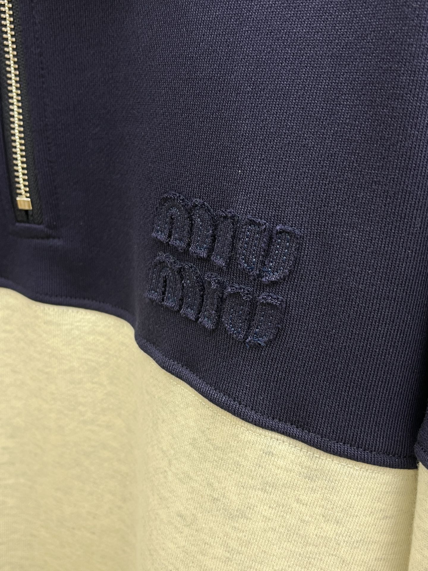 MiuMiu缪缪2025秋冬半拉链卫衣，藏青与浅灰拼接超有设计感，半拉链立领增添利落与随性感。精致品牌标